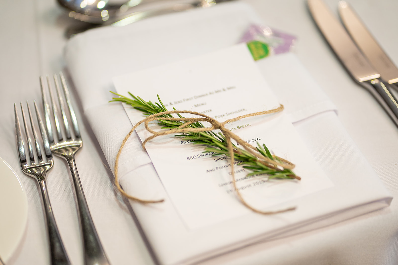 A place setting with a menu tied with rosemary and twine at Lanwades Hall