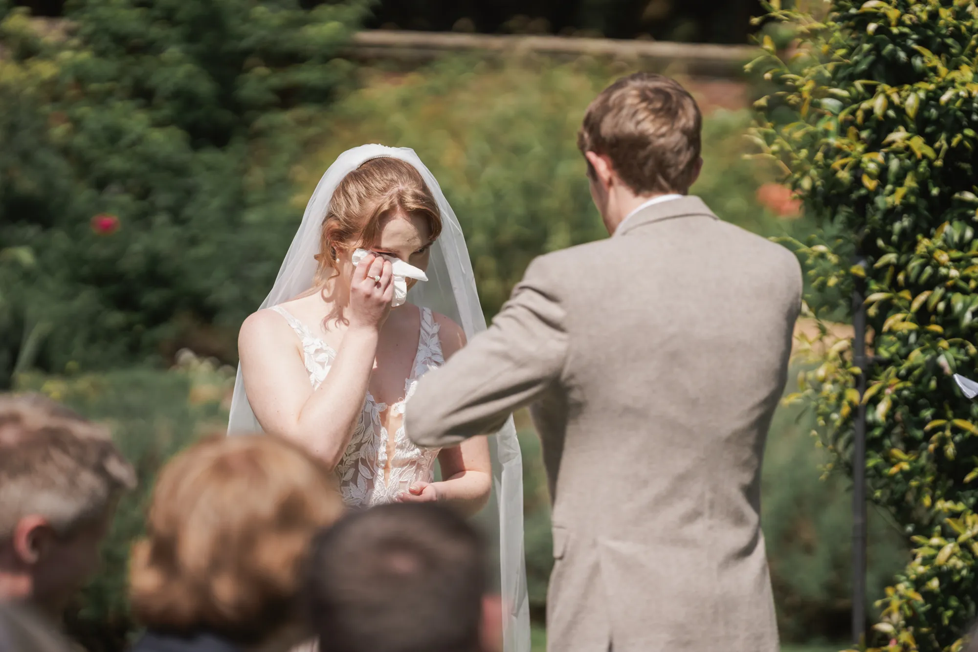 An emotional bride during her outdoor garden ceremony at Lanwades Hall