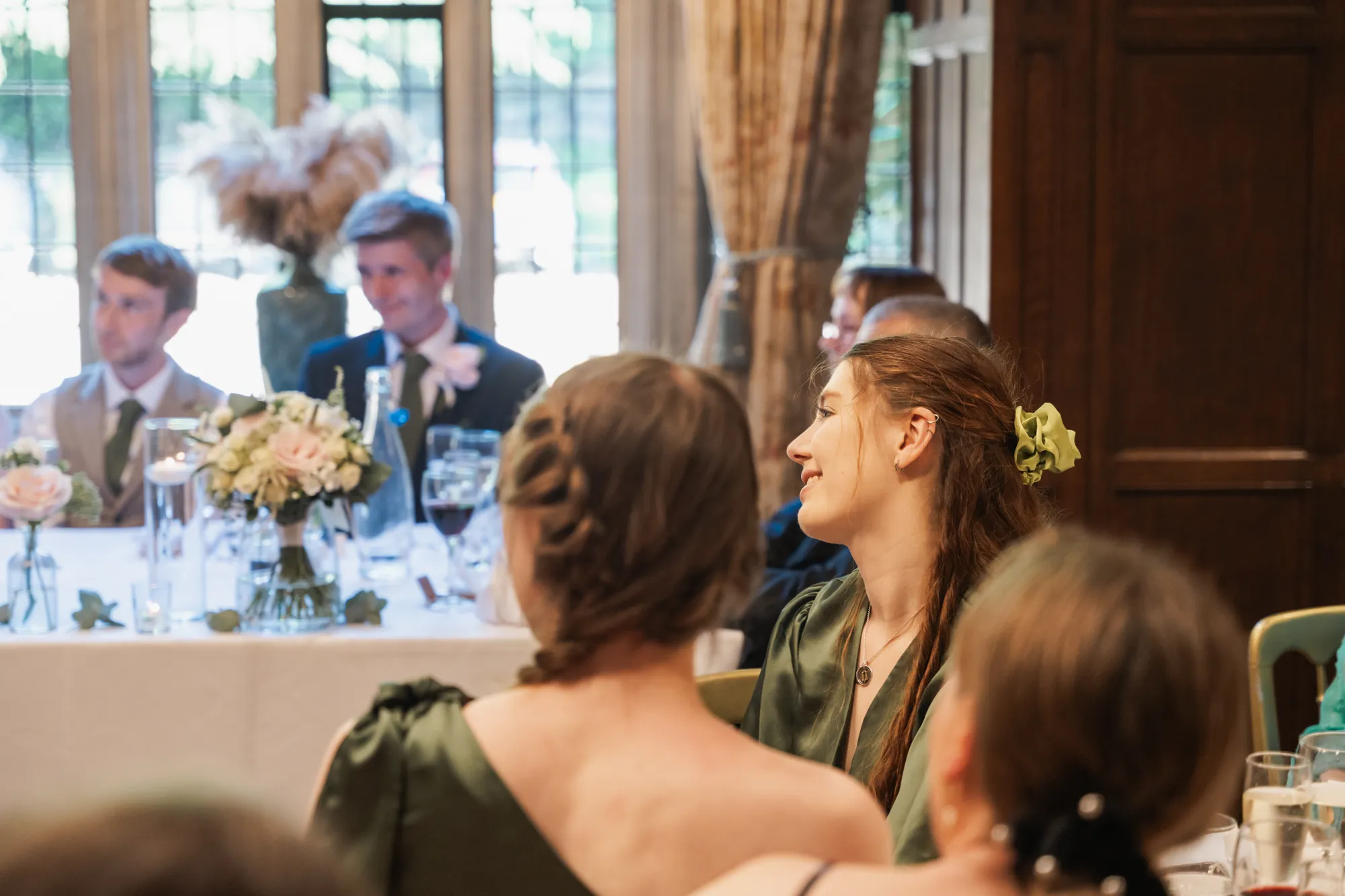 Wedding guests at dinner in the oak-panelled room at Lanwades Hall