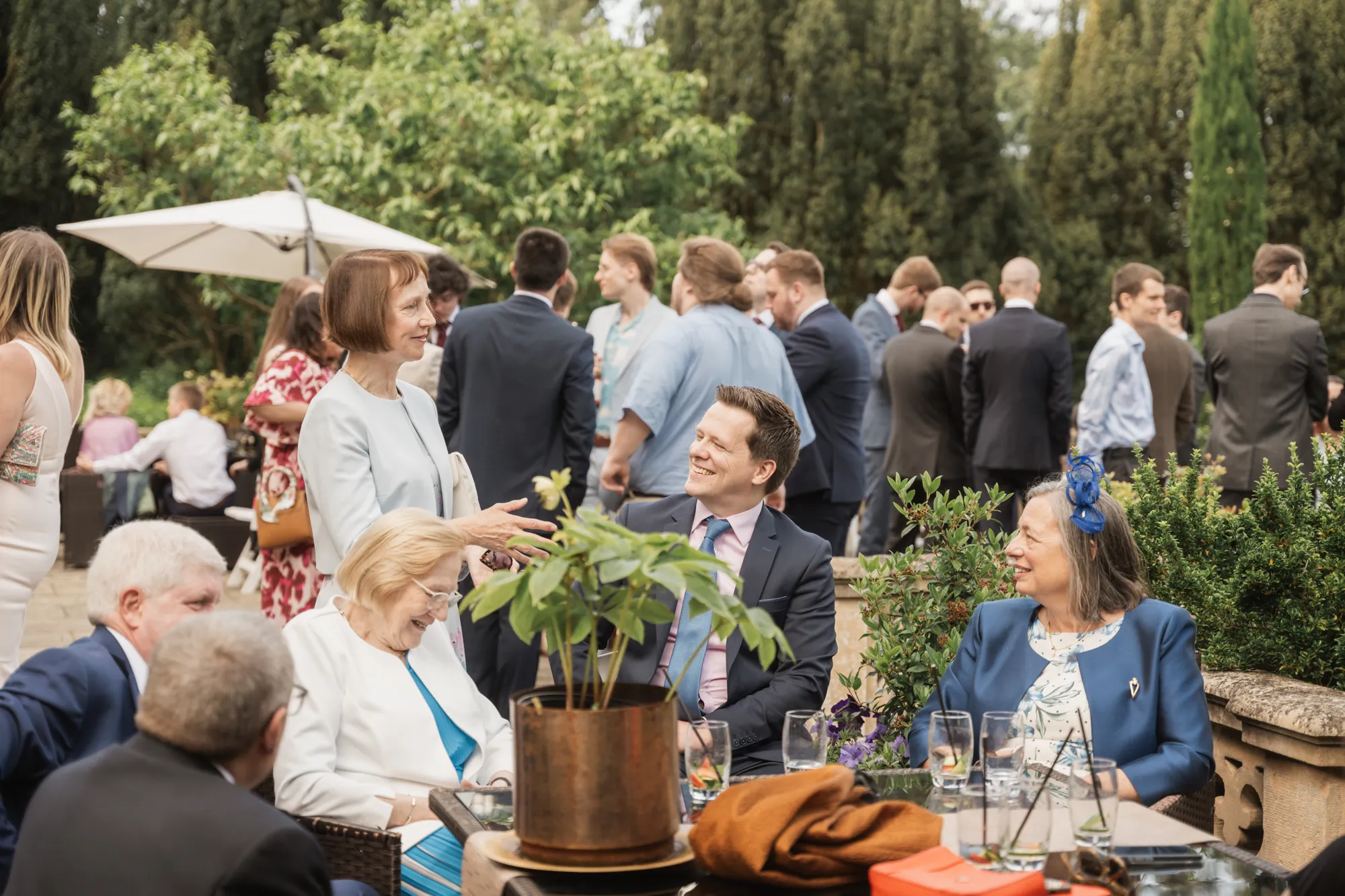 Guests enjoying drinks on the terrace in the sunshine at Lanwades Hall