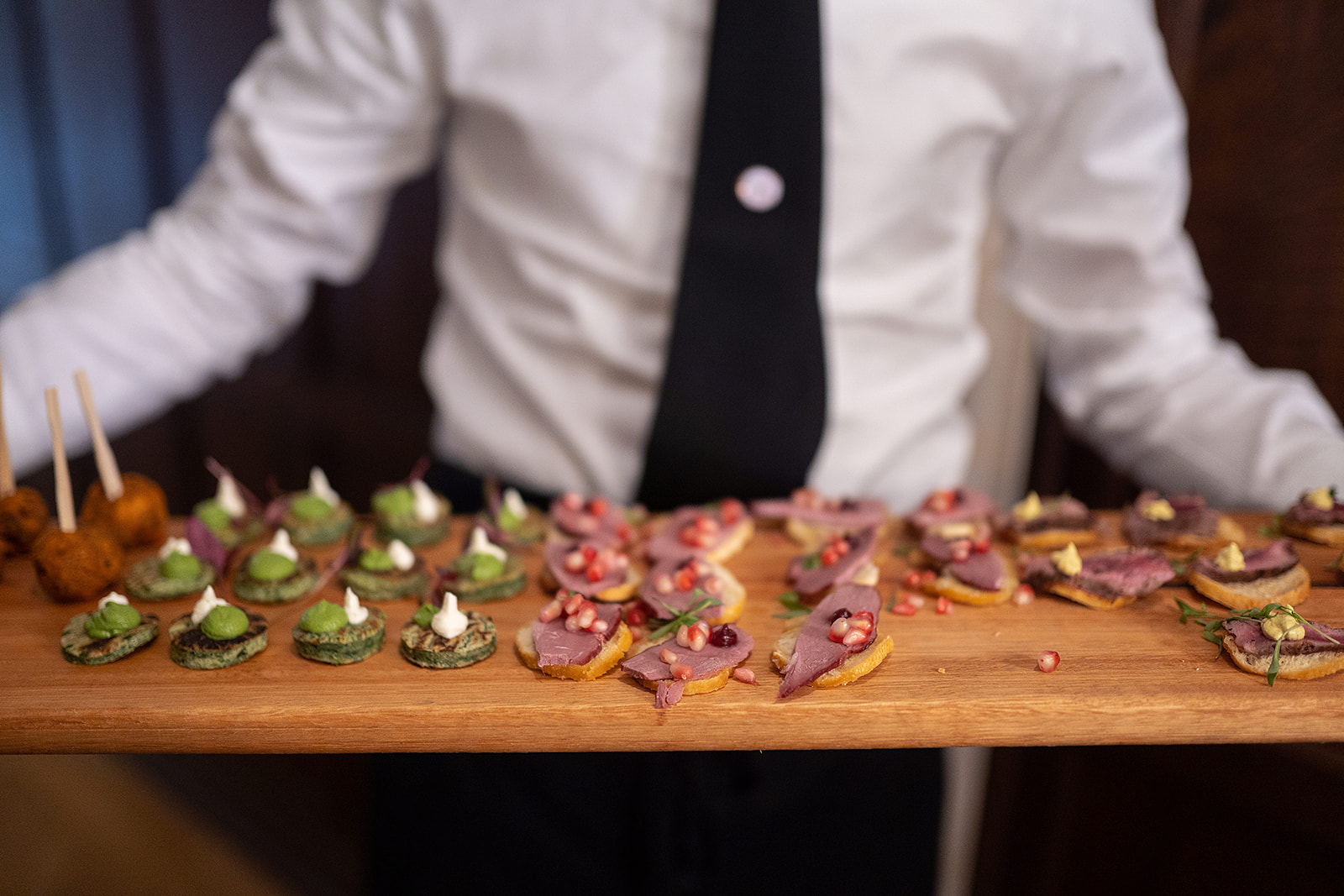 A server carrying a board of canapés at a corporate event at Lanwades Hall
