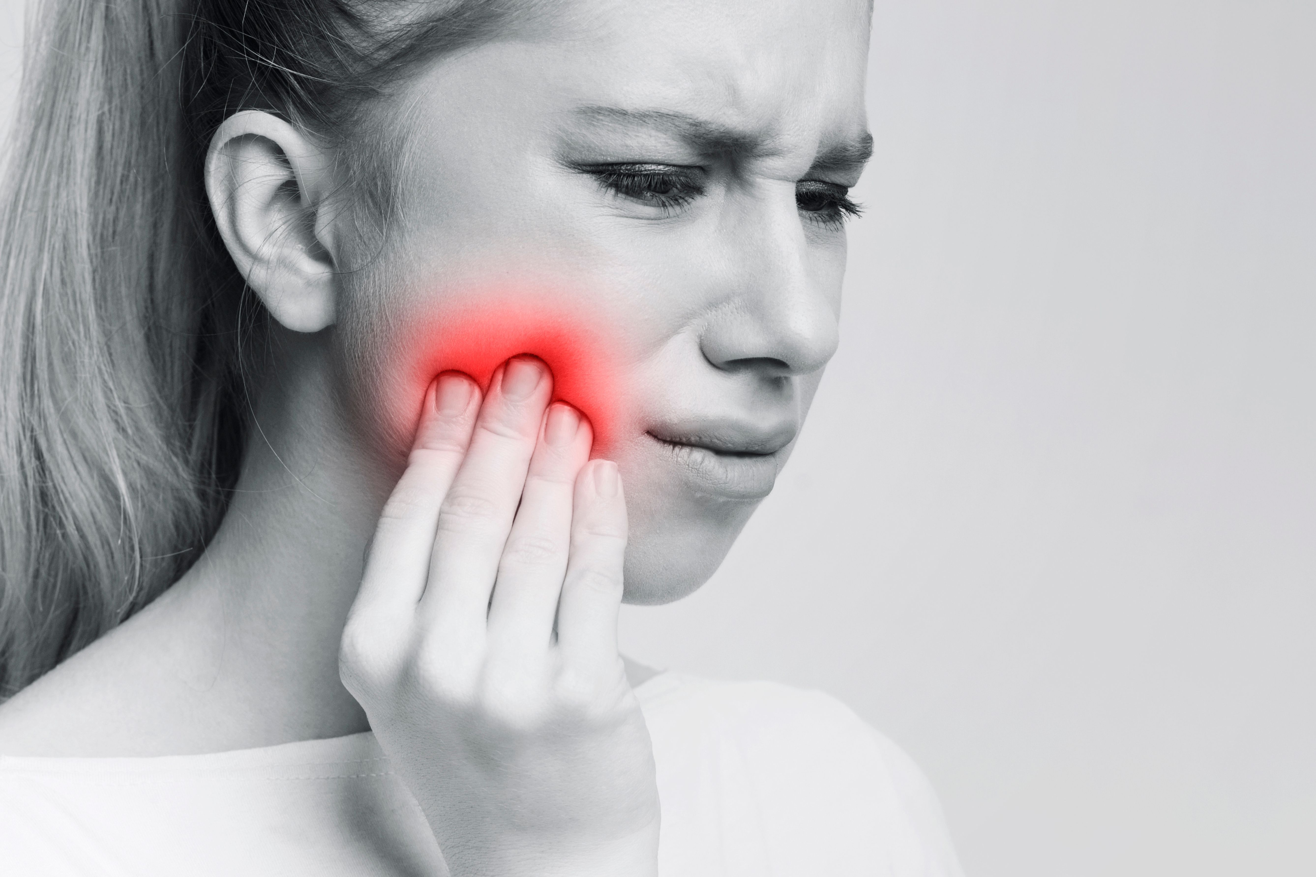 Woman holding her jaw in pain from a dental injury after an accident, Densley Dental in Henderson NV