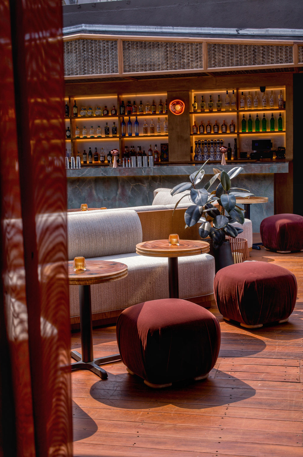 The rooftop bar, with burgundy velvet stools and backlit bottle shelves