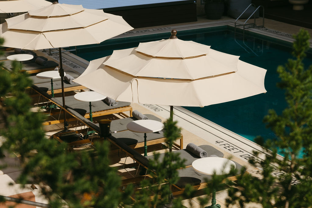 Cream umbrellas and loungers beside the pool, seen from above
