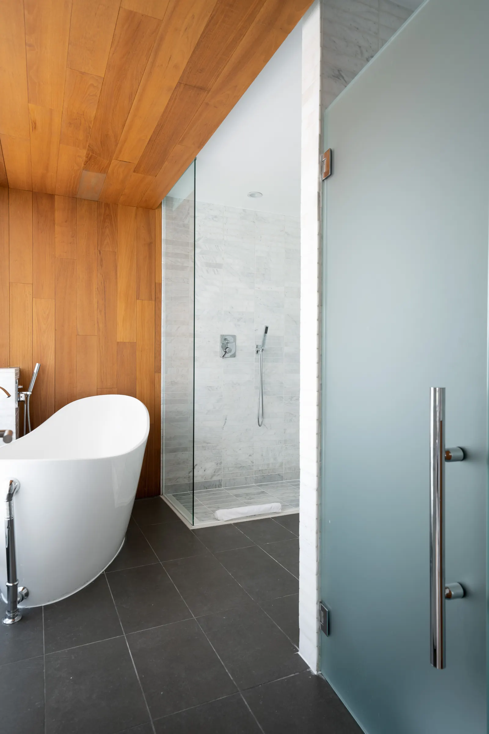 The suite bathroom, with a freestanding tub, walk-in shower and cedar ceiling