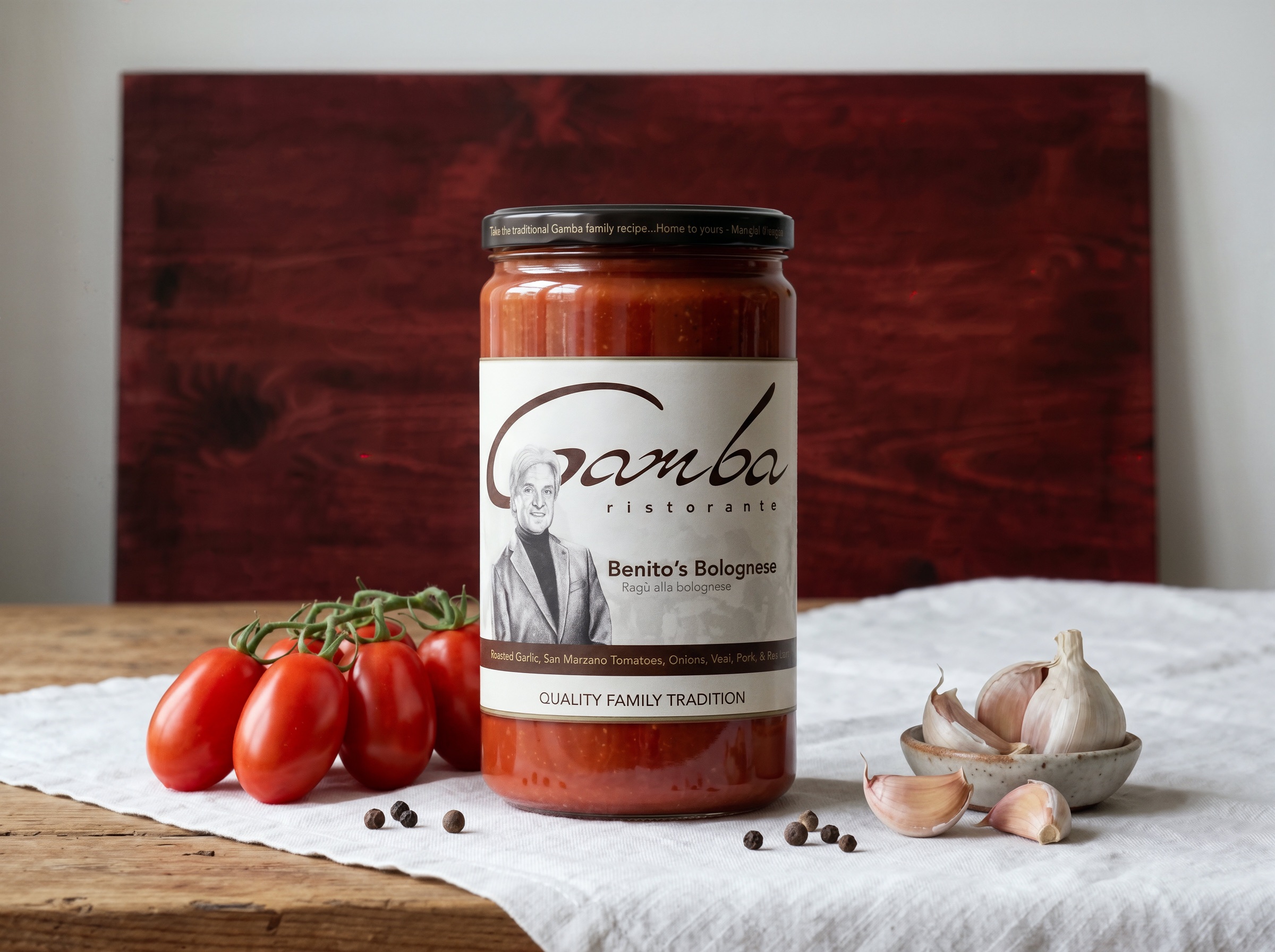 Jar of Gamba Ristorante’s Benito’s Bolognese with tomatoes and garlic on a linen-covered table.