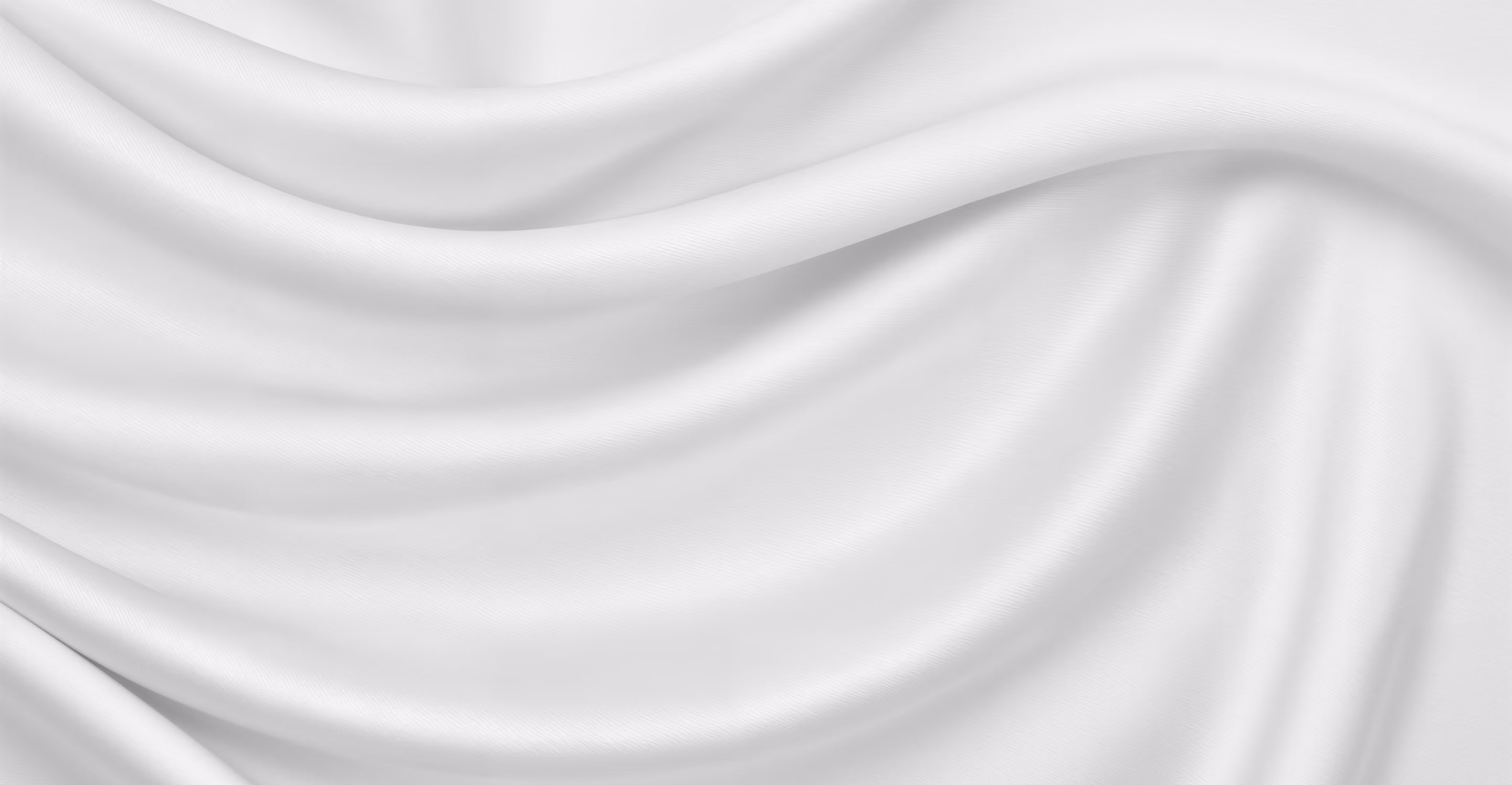Smooth white fabric with flowing folds and soft shadows creating a silky texture.