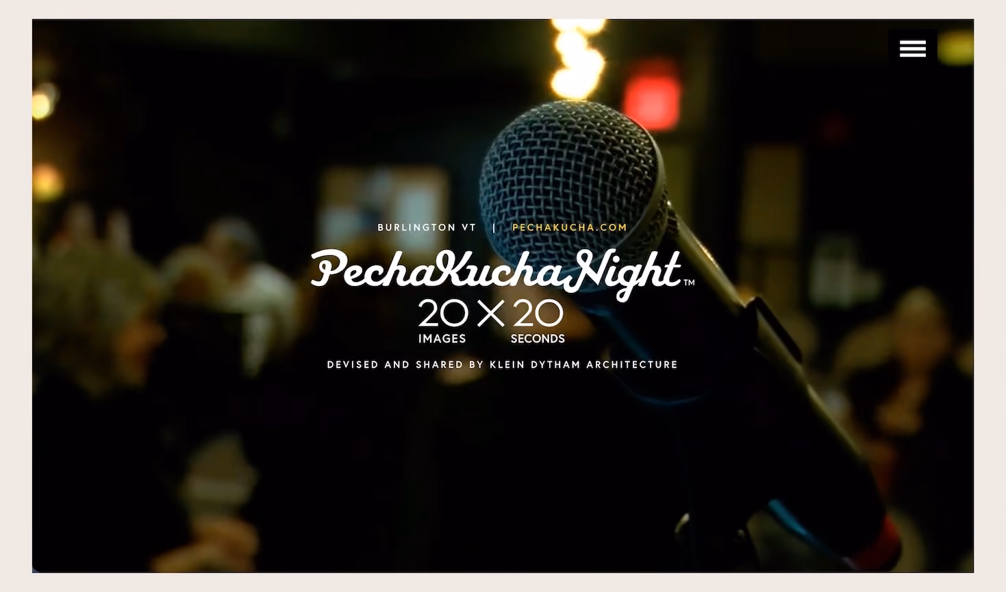Close-up of a microphone with a blurred audience in the background and text reading 'Burlington VT PechaKucha.com PechaKucha Night 20 images x 20 seconds devised and shared by Klein Dytham Architecture.'
