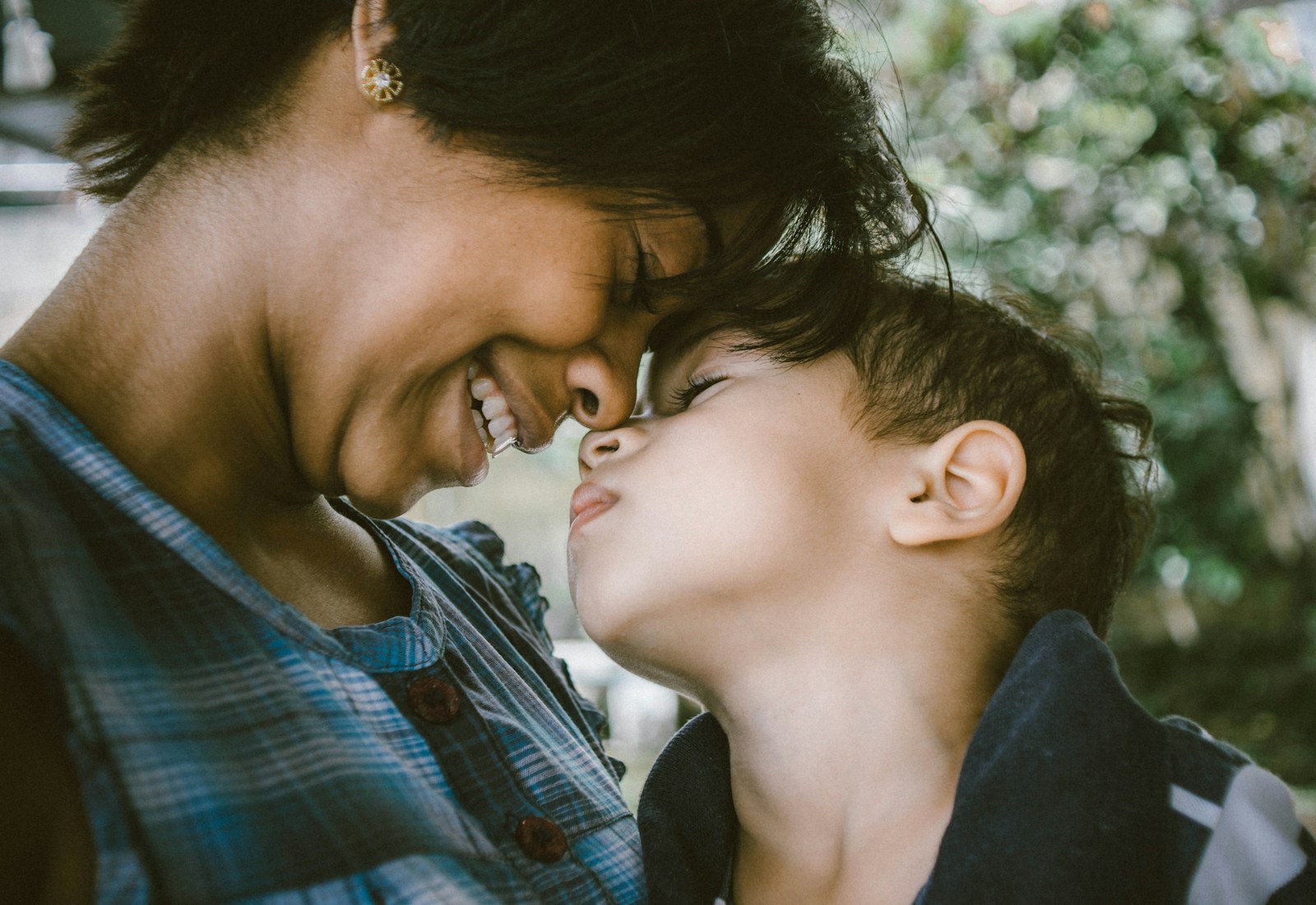 A mother and her son nose to nose, smiling