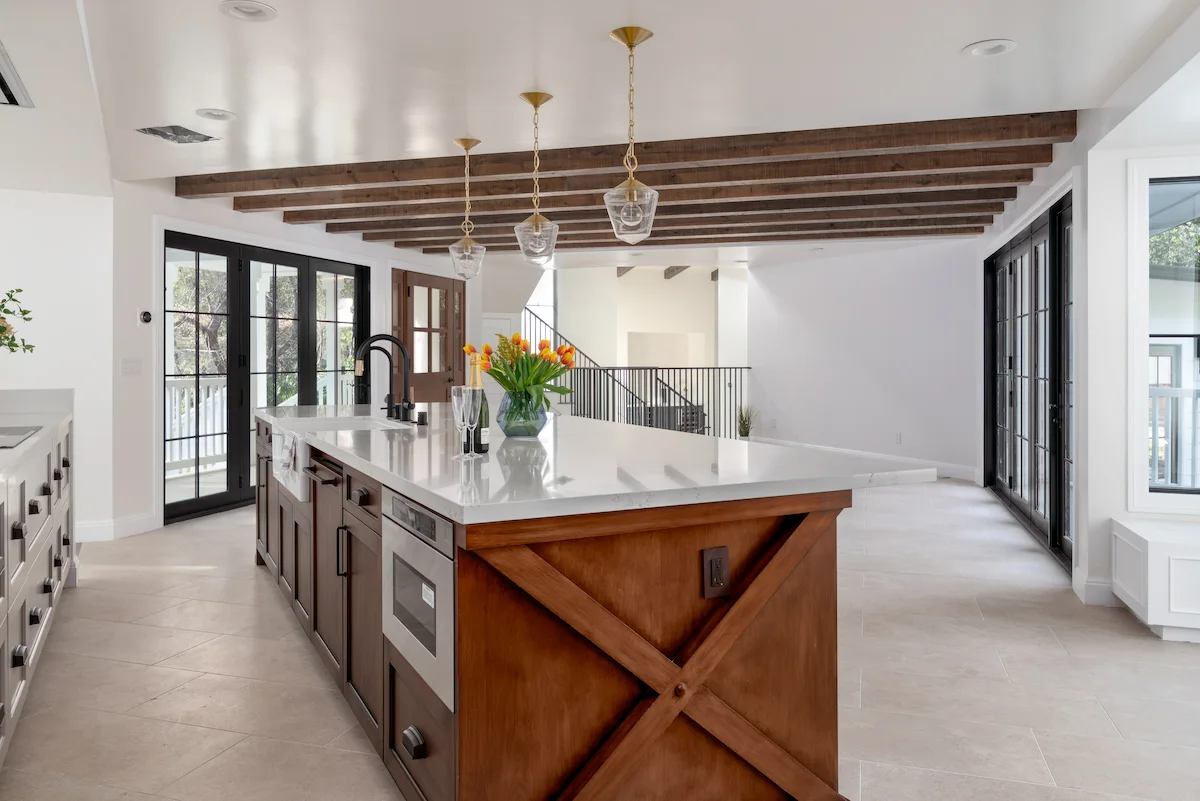 Pierce Rd new build project featuring a bright, modern kitchen with a large wood island, white countertops, and pendant lighting.