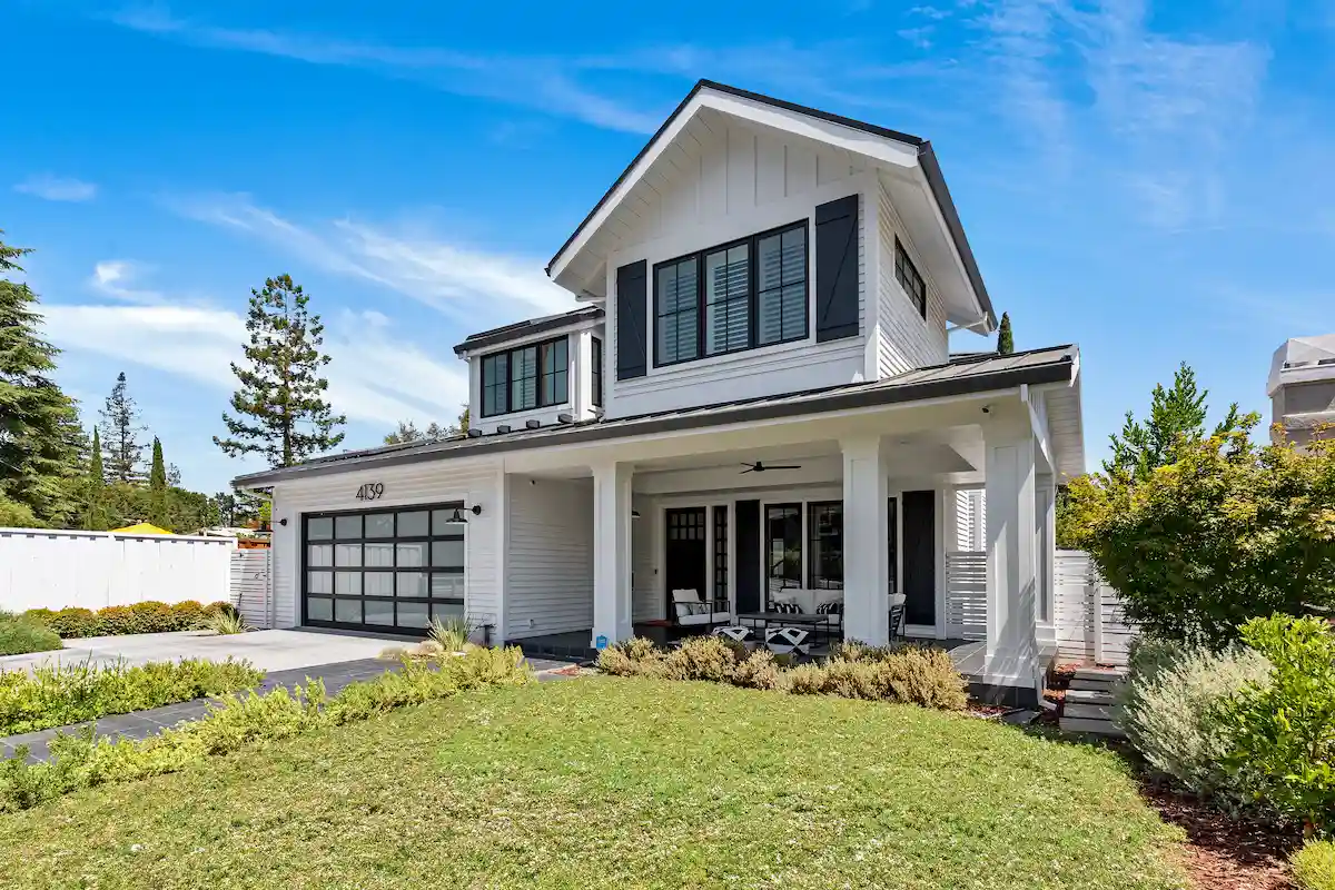 Amaranta Ave new build featuring beautiful white farmhouse-style home with a front porch and landscaped yard.