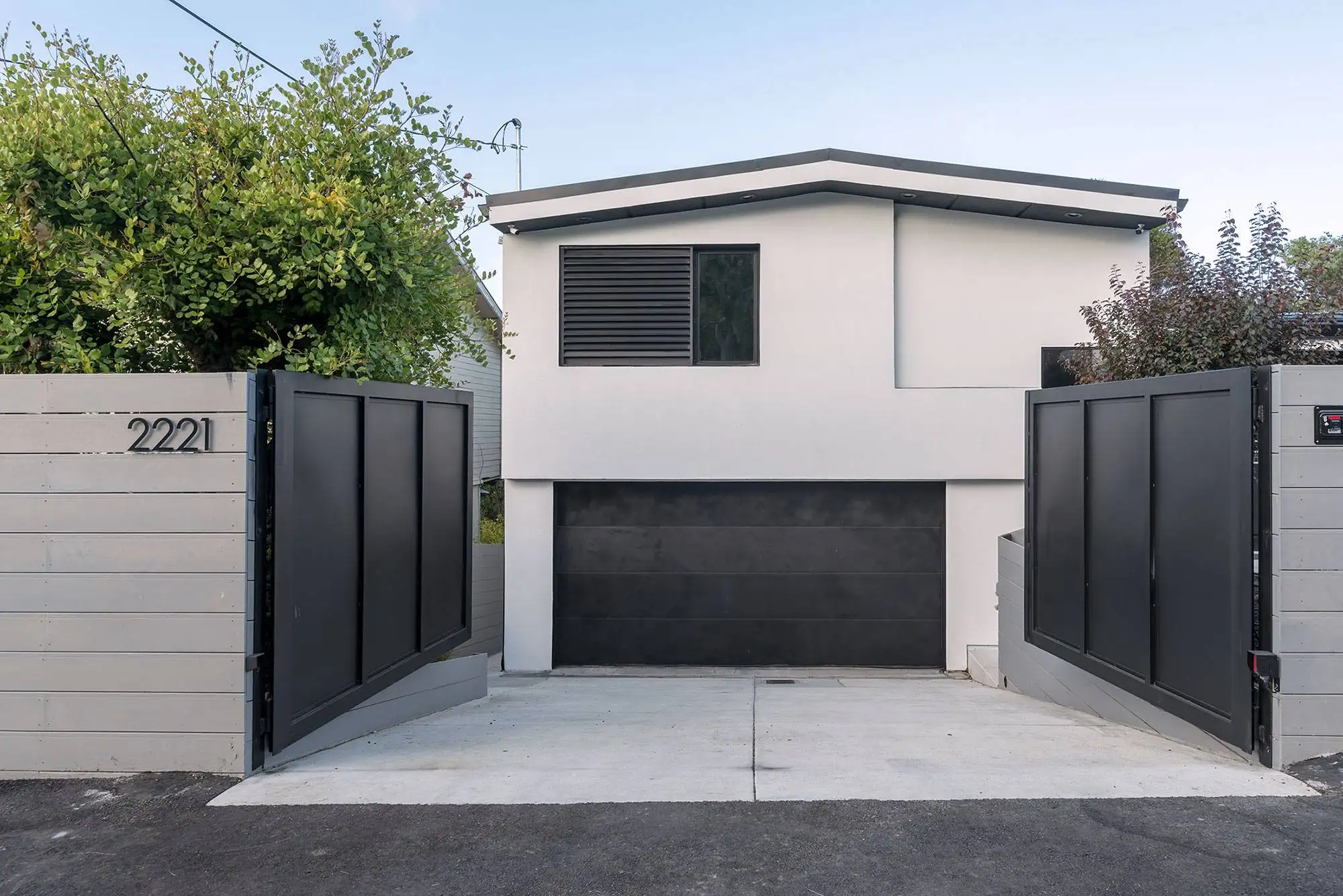 Modern energy-efficient custom home exterior with sustainable green building design and modern security entry gates.