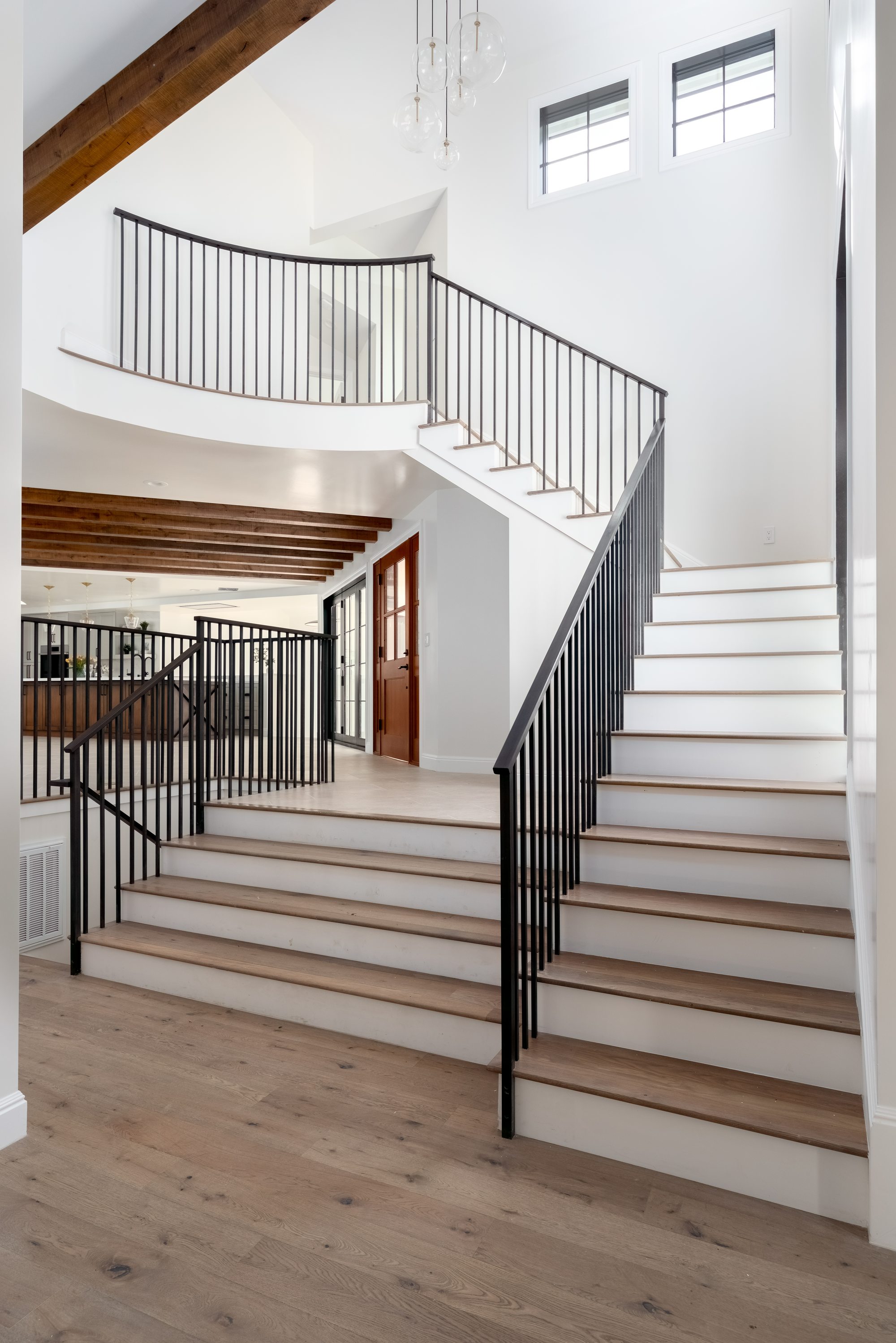 Pierce Rd, a new build in Saratoga by Greenberg, the curved staircase with a black iron rail