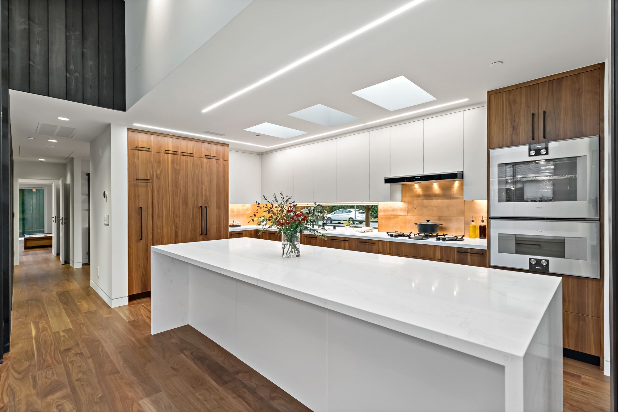 Santa Rita, a new build in Palo Alto by Greenberg, the kitchen with walnut cabinetry and a quartz island