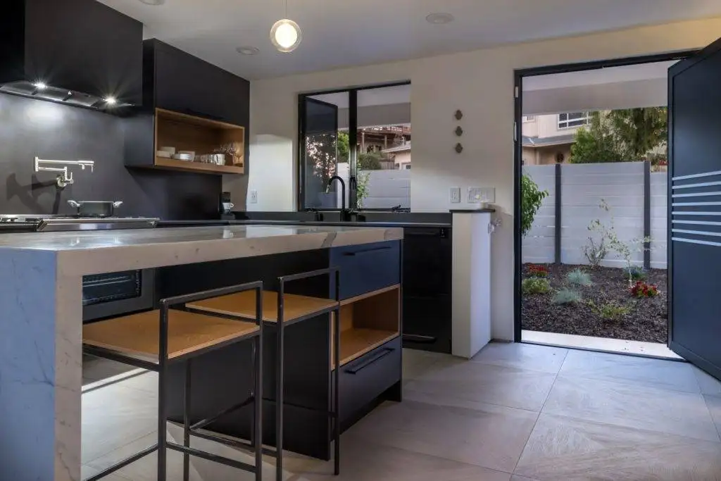 Thurm Avenue kitchen with dark cabinets, a light island countertop, and a wide opening to an outdoor area