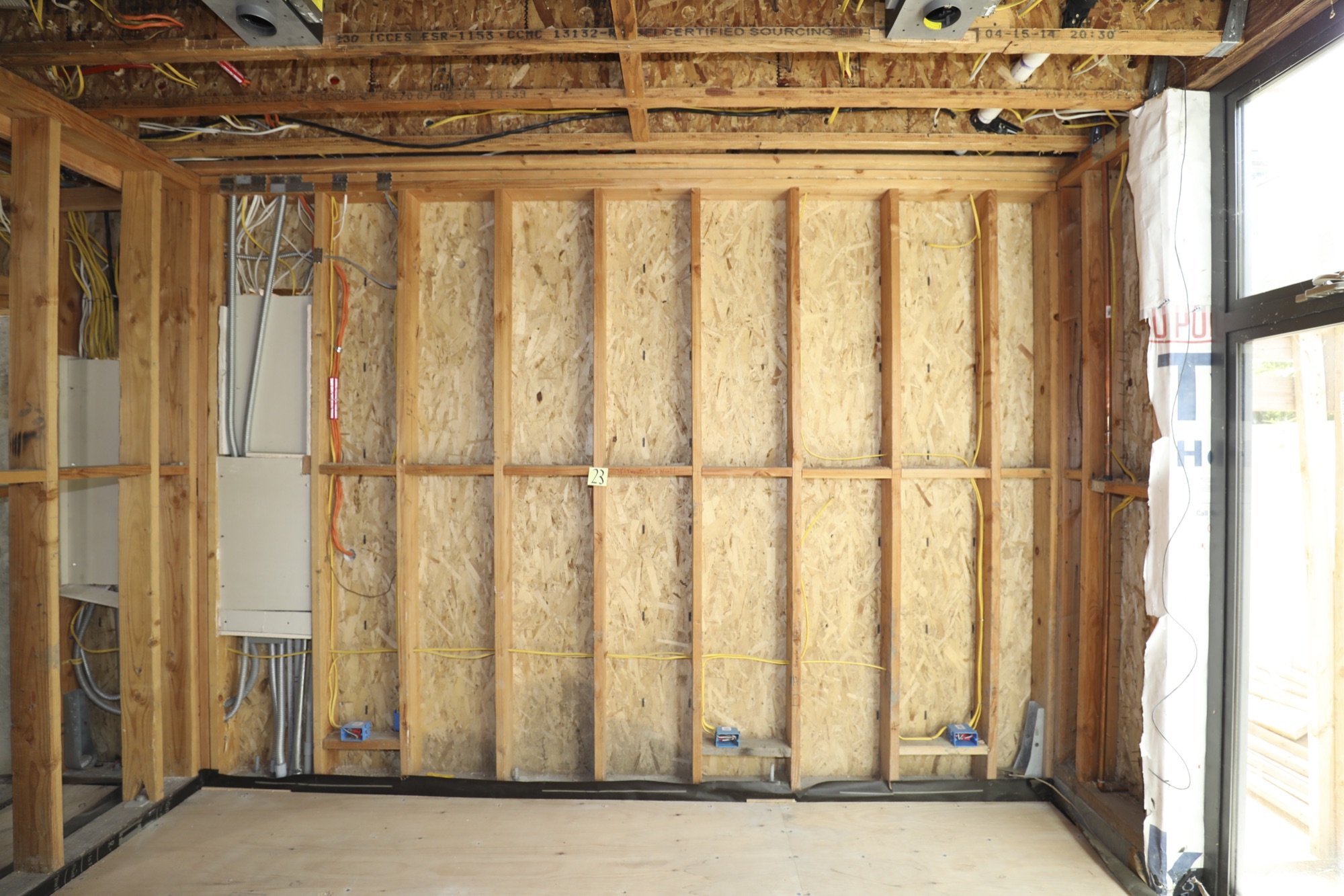 Exposed wall framing and OSB sheathing with electrical rough-in at a Greenberg home in Palo Alto