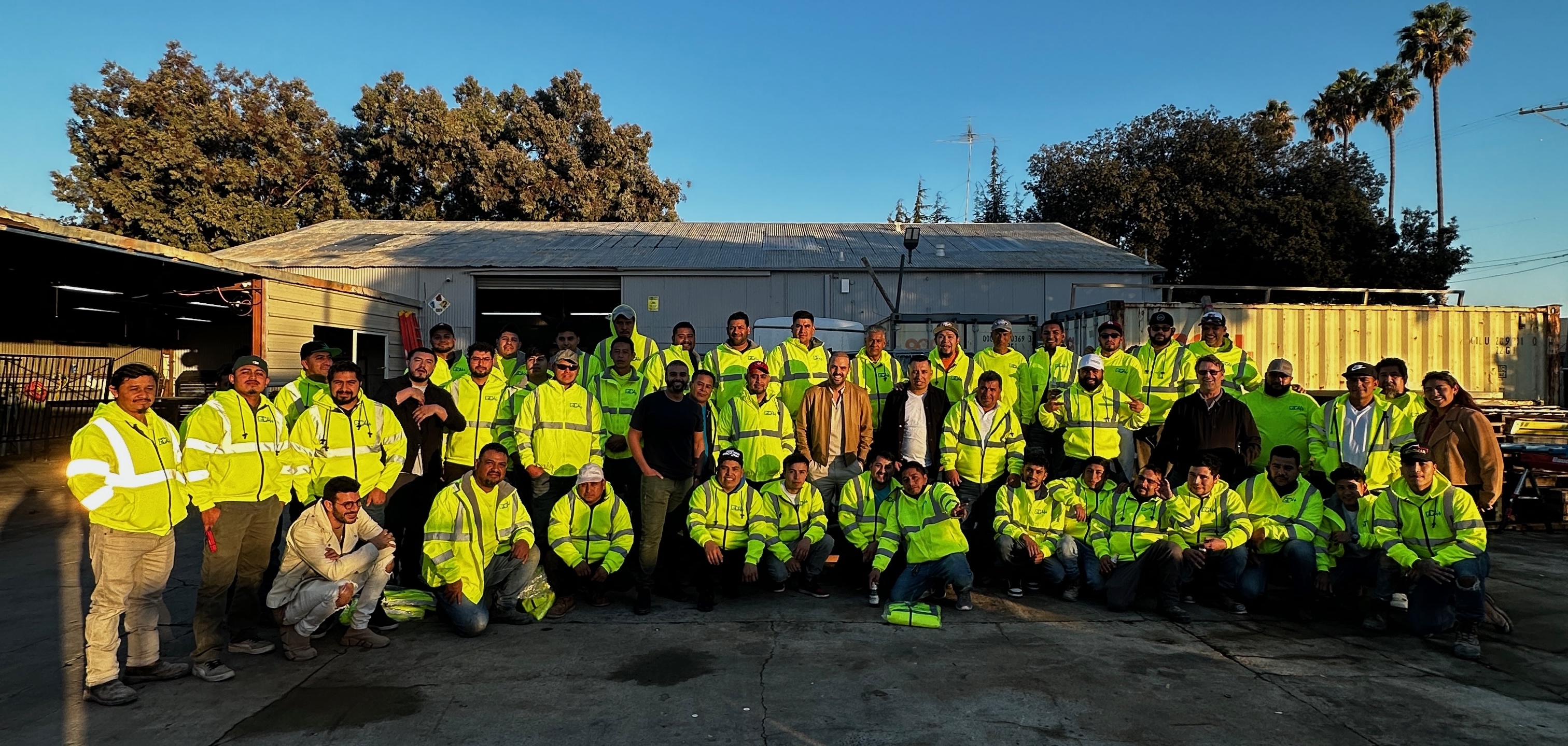 The Greenberg team together in the yard, crews in high-visibility jackets alongside the office staff