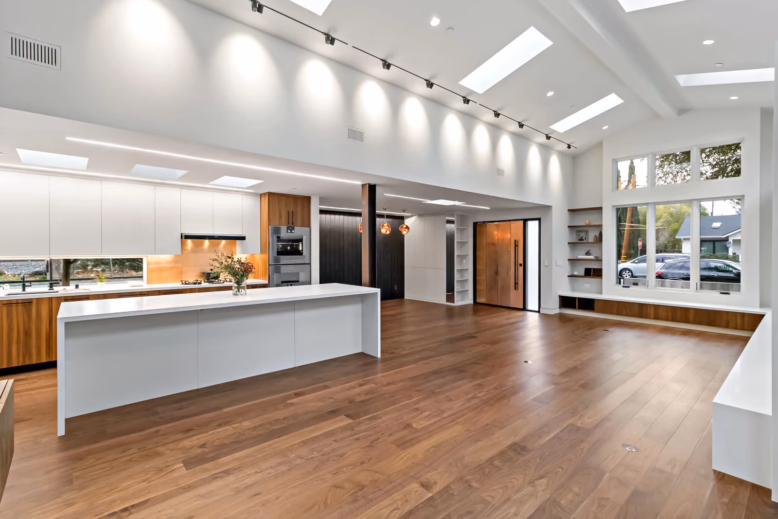Santa Rita custom home in Palo Alto, with a quartz kitchen island, walnut cabinetry and a skylit living space.