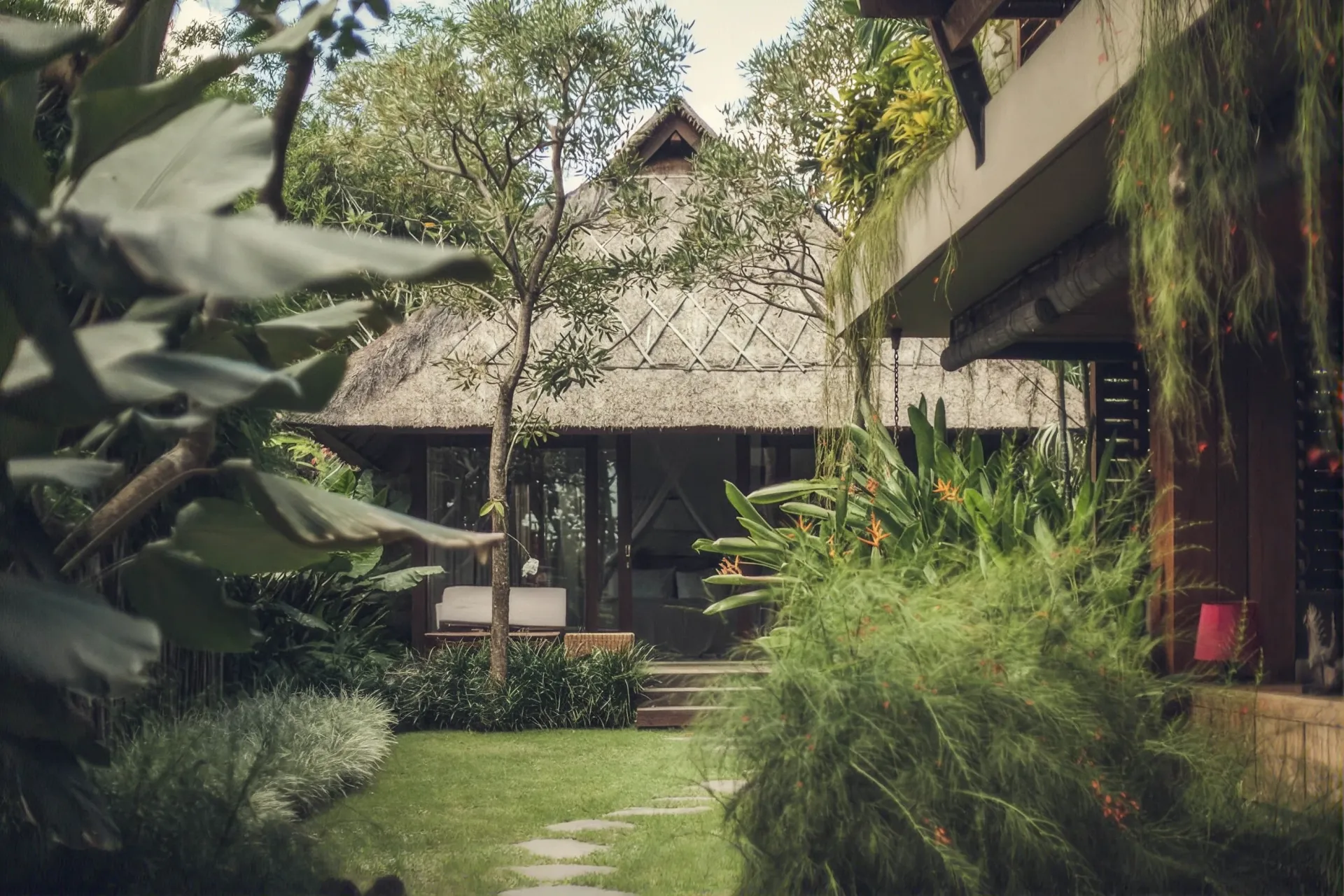 Thatched villa across the garden lawn