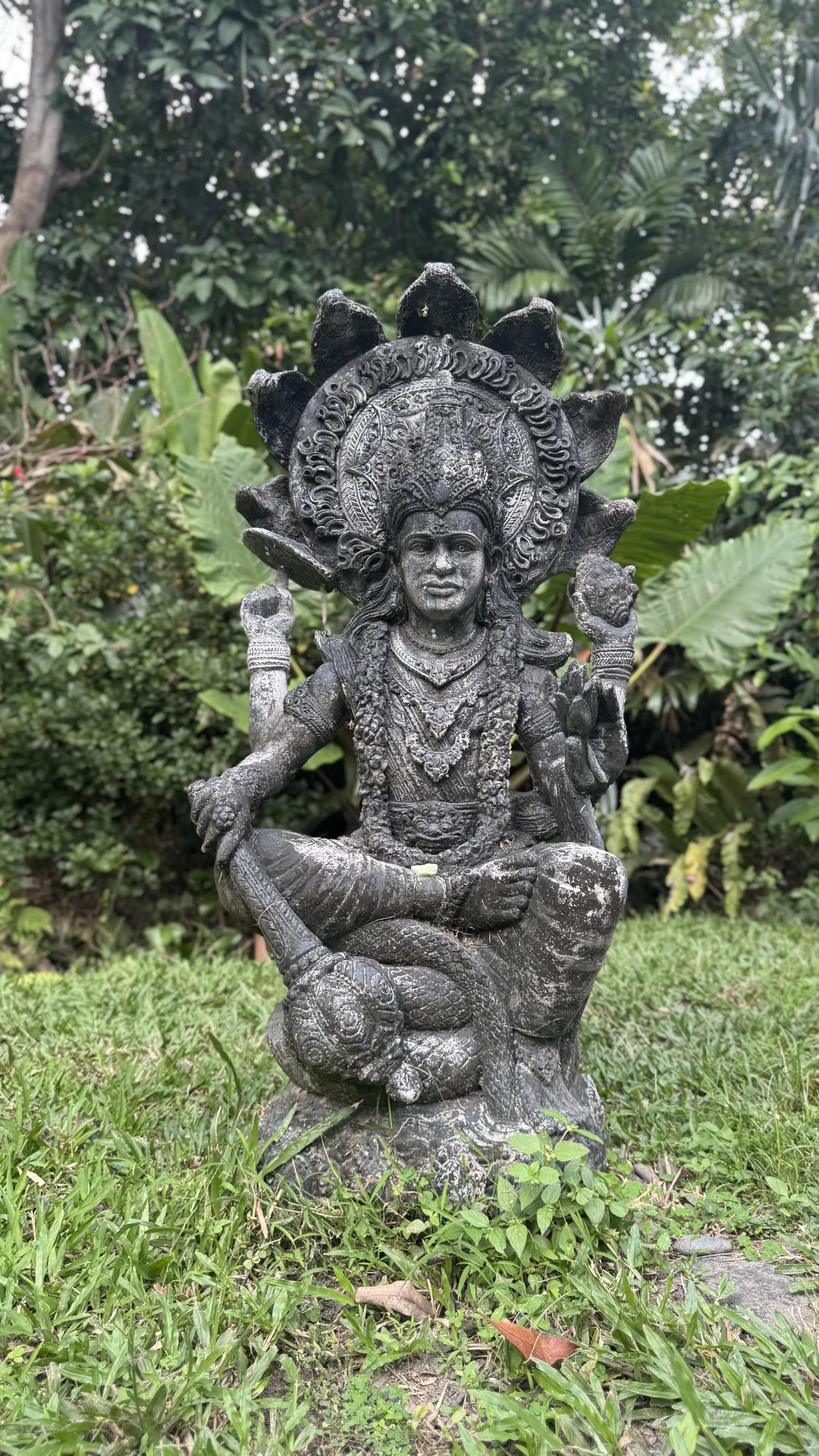 Stone deity figure set in the lawn