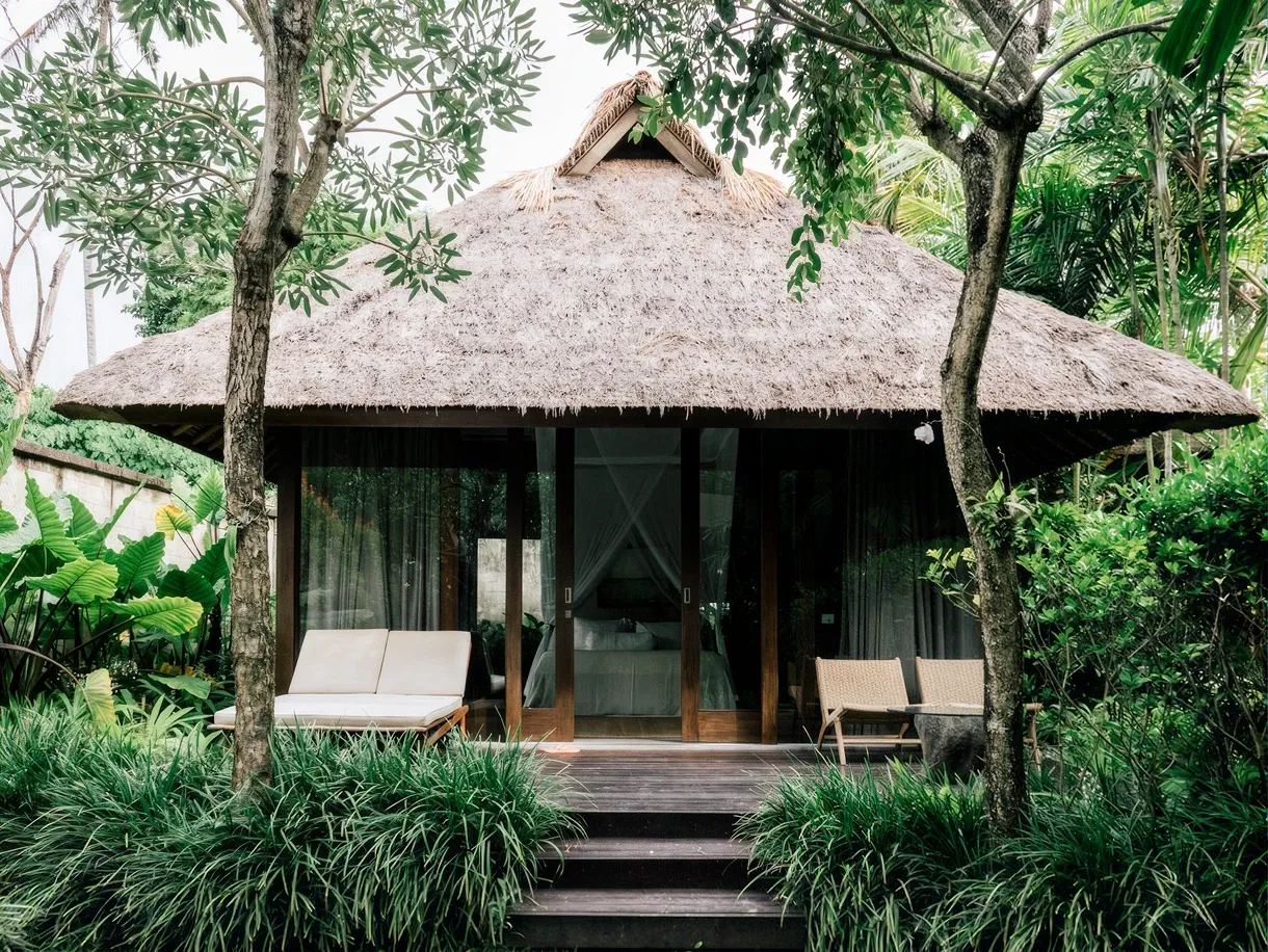 Thatched guesthouse with daybeds on the lawn