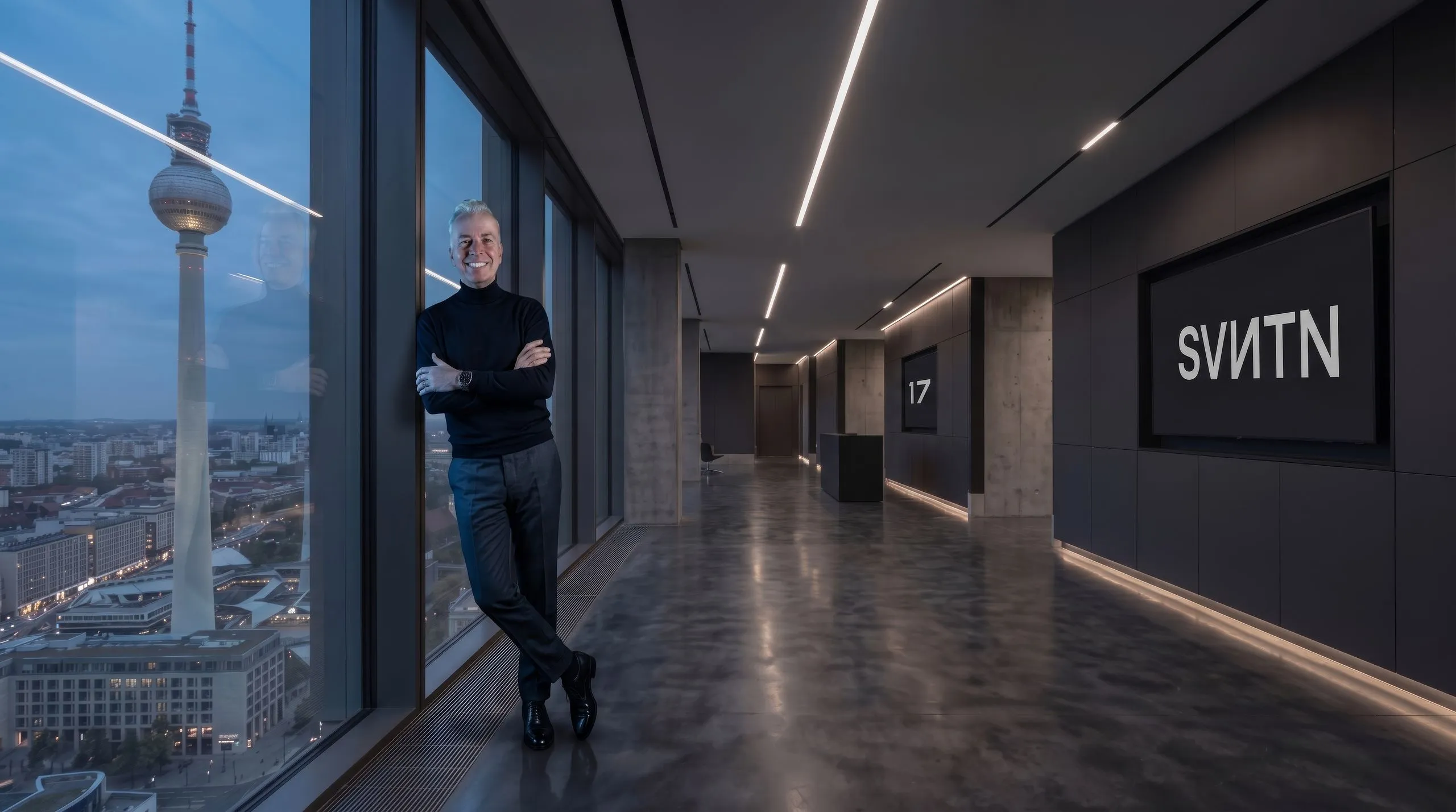 Ralf Mühlenhöver lehnt im SVNTN-Büro in Berlin an der Fensterfront, dahinter der Fernsehturm
