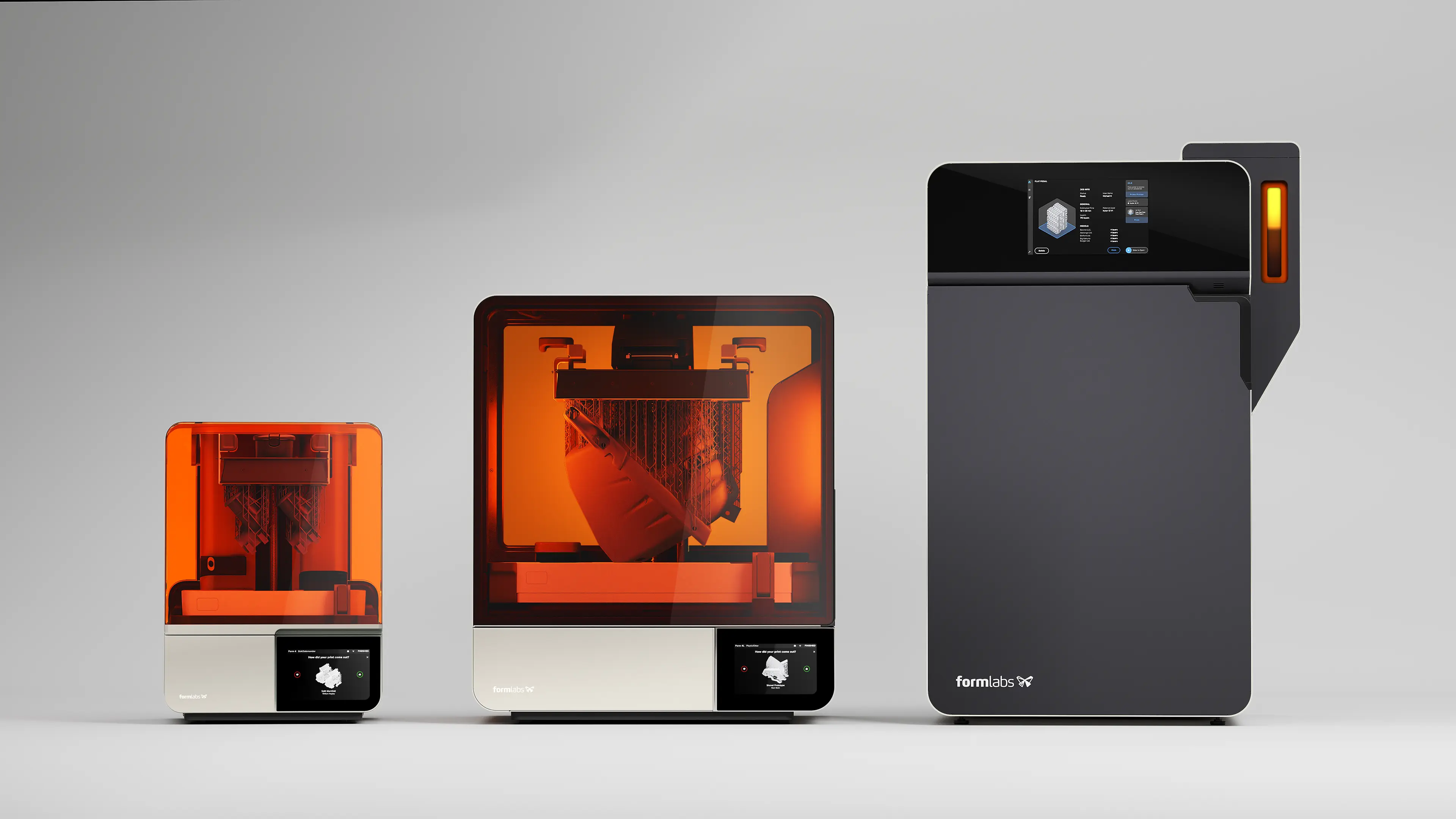 Three Formlabs 3D printers: two resin printers with orange covers and a larger dark grey unit