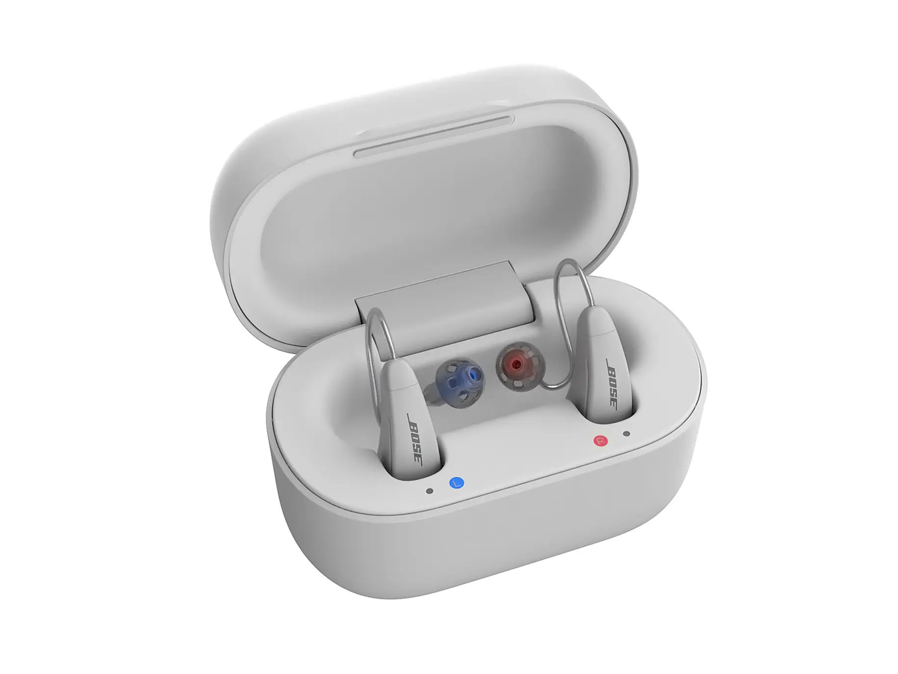 White Bose hearing aids placed inside an open white charging case with left and right indicators.