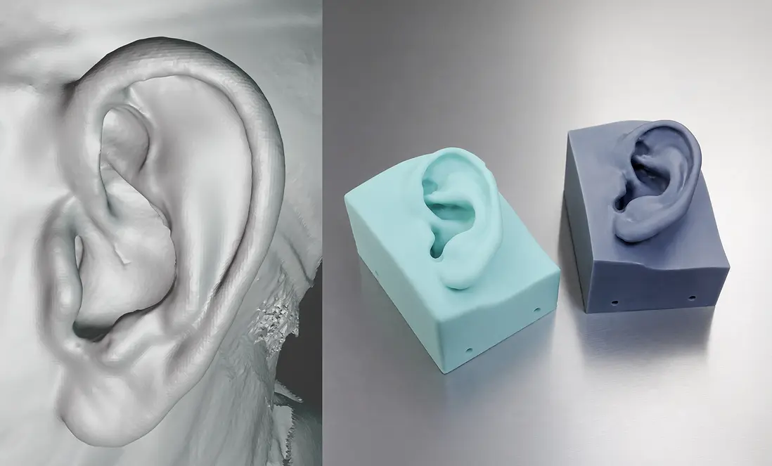 Side-by-side comparison showing a detailed digital 3D ear scan on the left and two physical silicone ear molds in blue and purple on the right, placed on a reflective surface.