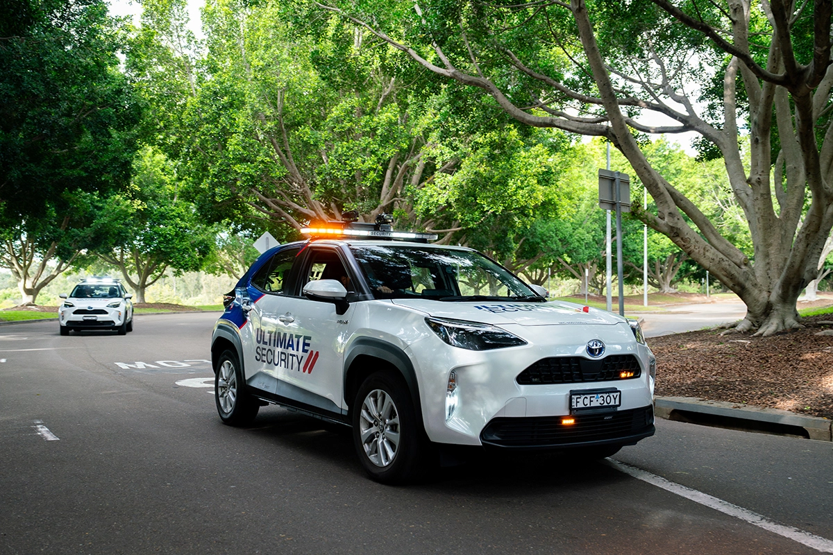 Ultimate Security mobile patrol vehicle driving on duty for commercial property protection.