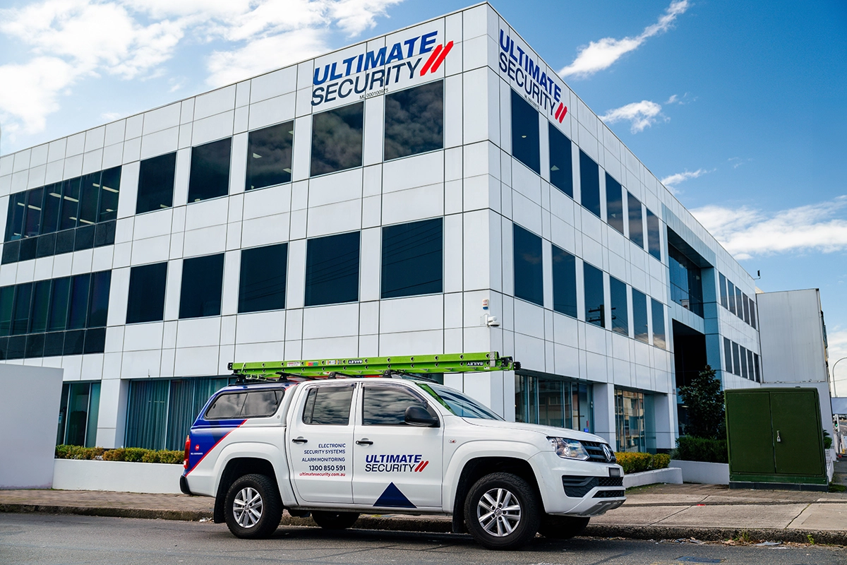 Ultimate Security headquarters building with branded response vehicle parked outside.