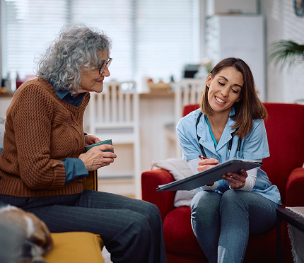 A clinician consulting with an older patient at home