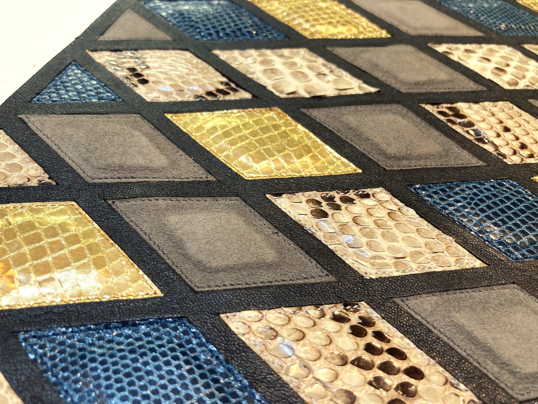 Geometric leather marquetry with blue, gold and neutral textured inlays