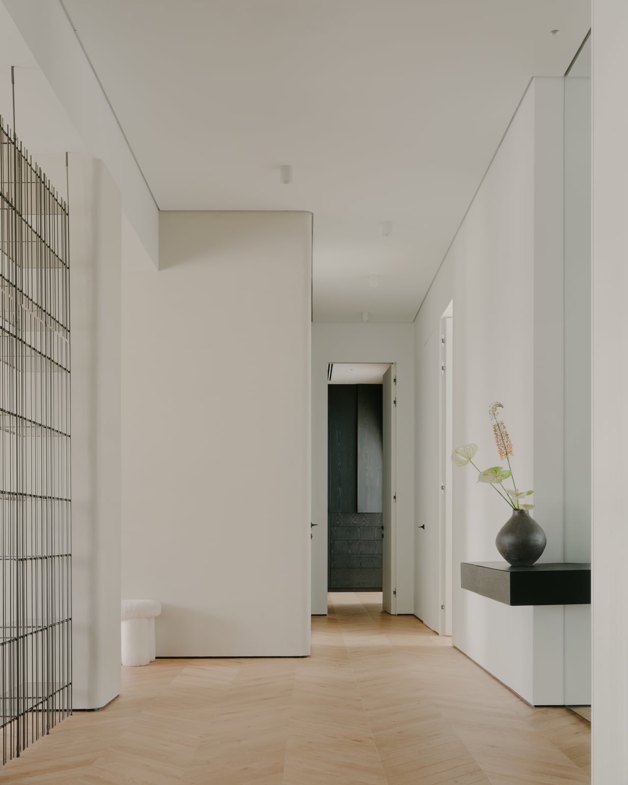 Corridor with a metal grid screen and a dark doorway at the end
