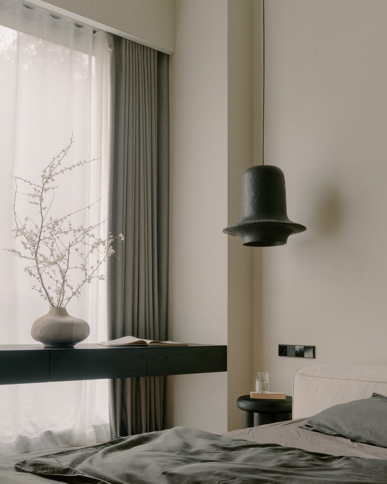 Bedroom with a pendant light, a black ledge shelf and sheer curtains