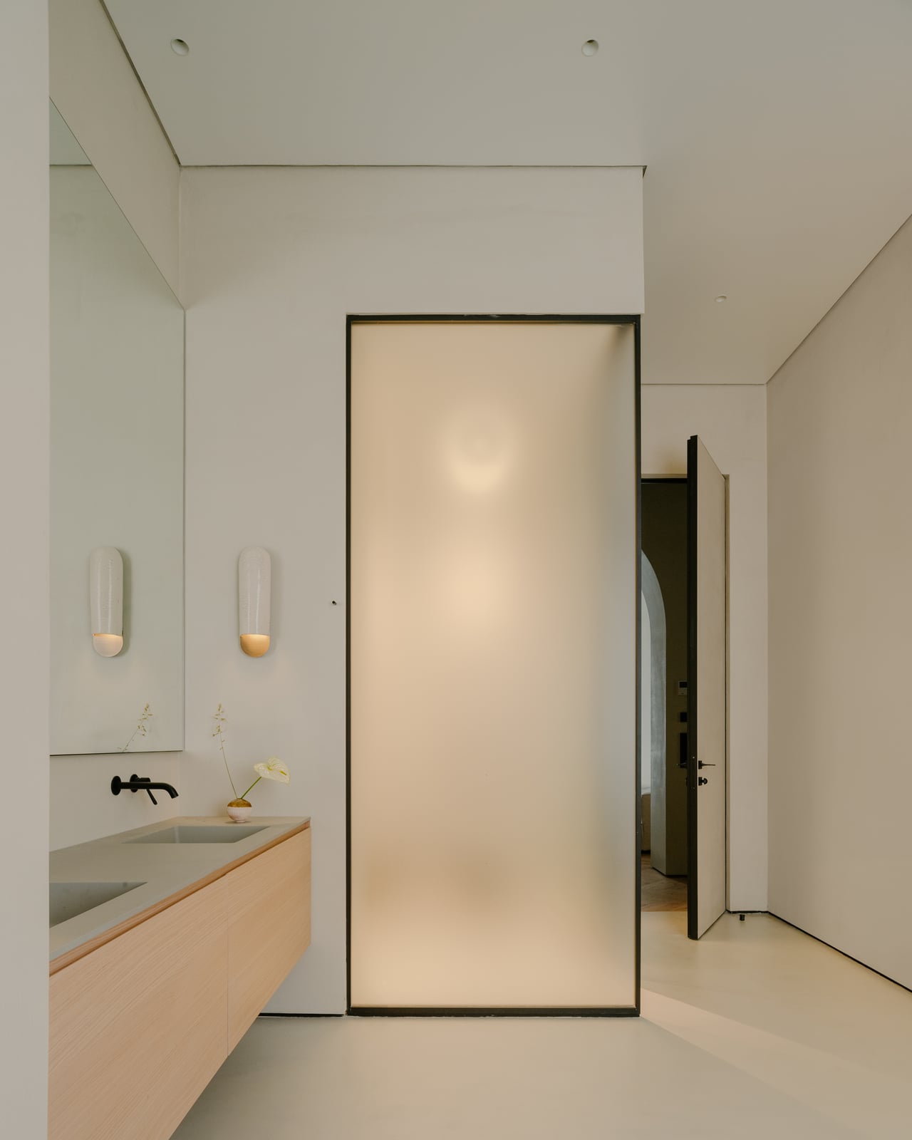 Bathroom with a backlit glass panel, a wall-hung basin and a wooden counter