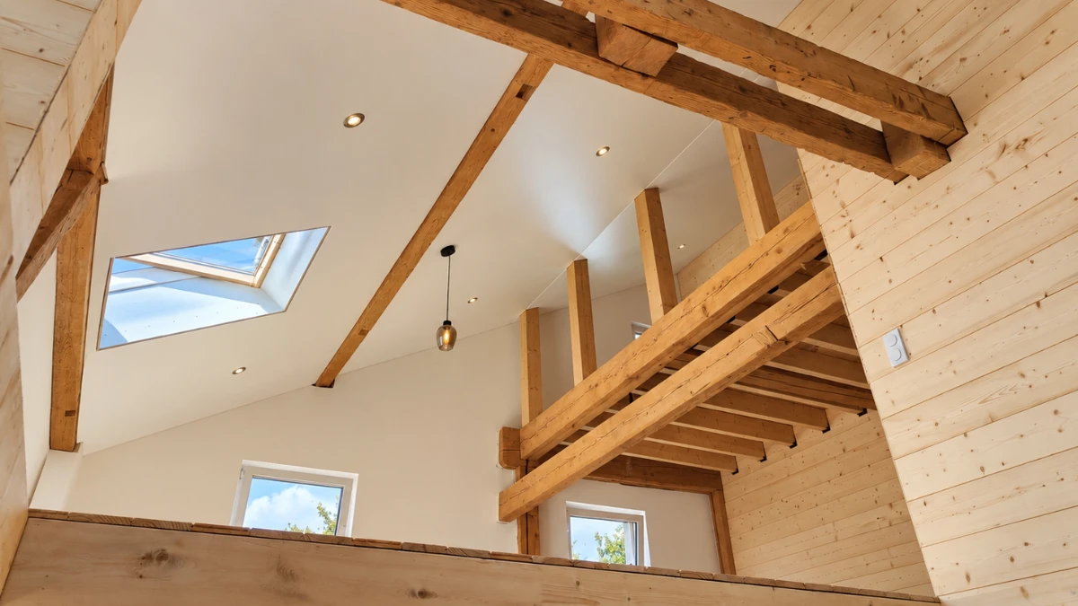 Plafond tendu autour de luminaires et de poutres sous un toit