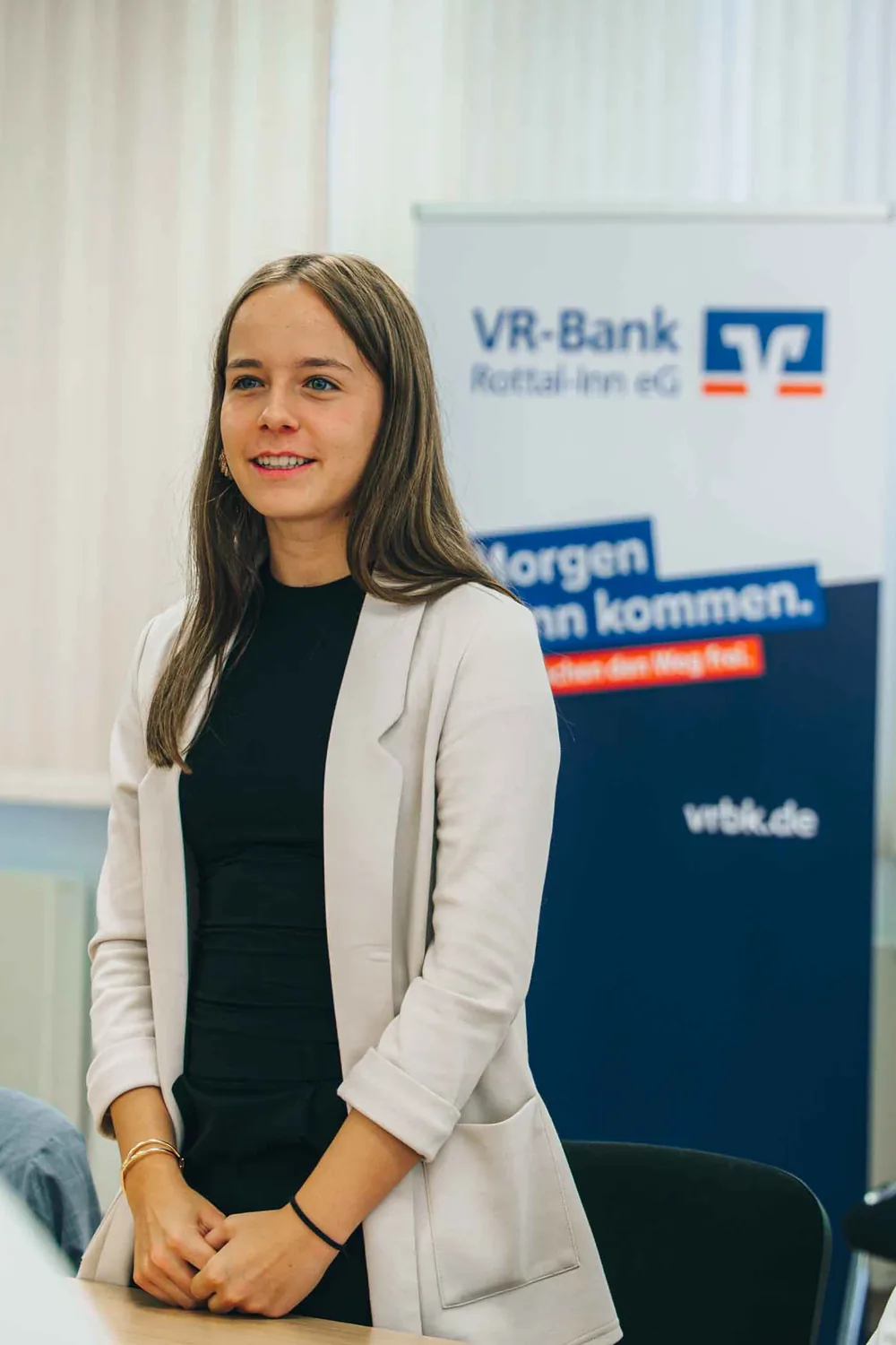 Azubi vor dem Banner „Morgen kann kommen“ der VR-Bank Rottal-Inn