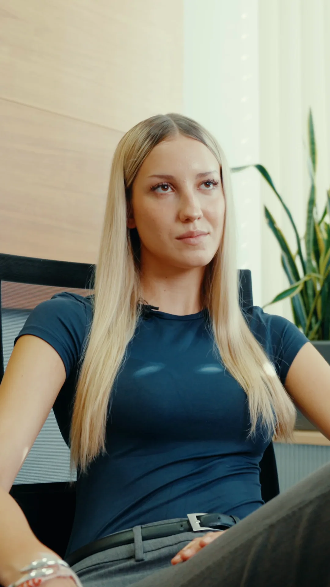 Azubine sitzt am Arbeitsplatz und blickt zur Seite – Reel „Zu steif?“