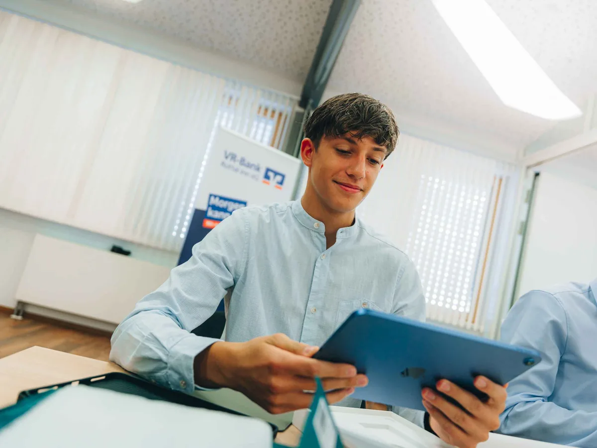 Junger Azubi mit Tablet in der Einführungswoche