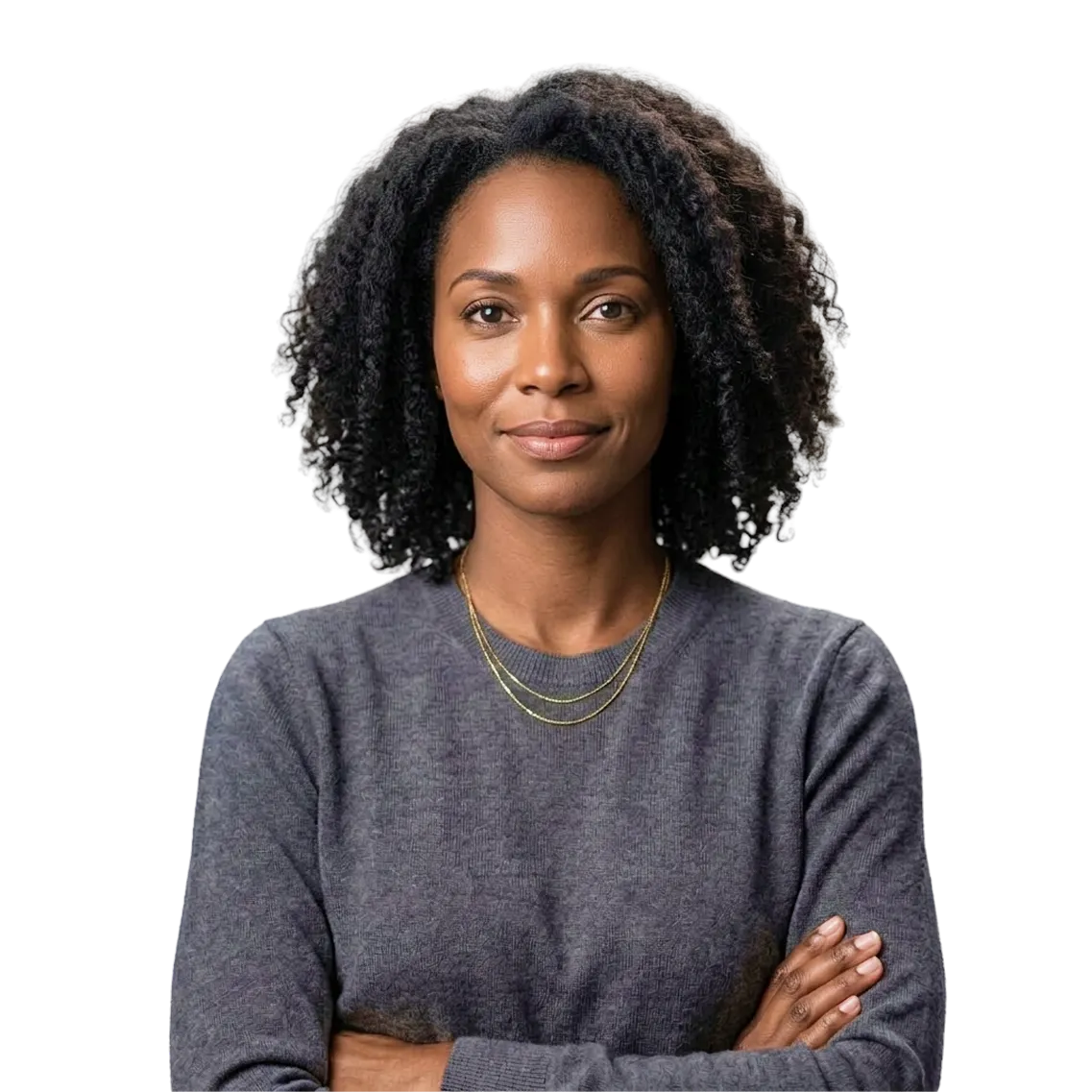 Confident woman with curly hair wearing a gray sweater and gold necklaces, arms crossed, looking directly ahead with a calm expression.