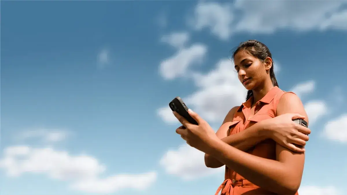 Woman wearing the Visible armband looking at her phone