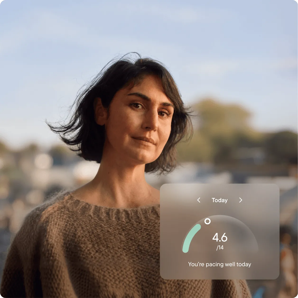 A woman with short dark hair outdoors in evening light. A Visible app overlay shows 4.6 out of 14 PacePoints used today, with the message ‘You’re pacing well today'