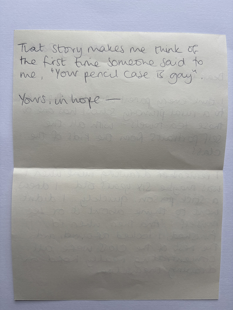 Handwritten note on cream paper reading: 'That story makes me think of the first time someone said to me, "Your pencil case is gay." Yours, in hope —'.