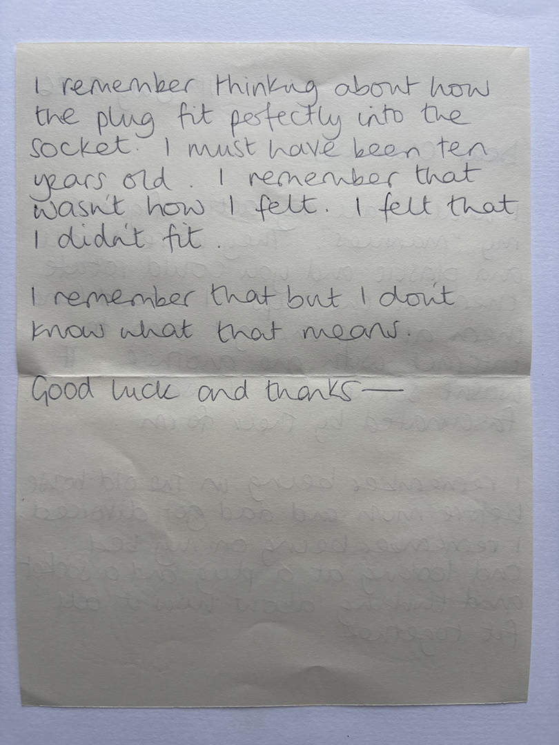A handwritten note on cream-colored paper reading: "I remember thinking about how the plug fit perfectly into the socket. I must have been ten years old. I remember that wasn’t how I felt. I felt that I didn’t fit. I remember that but I don’t know what that means. Good luck and thanks—"