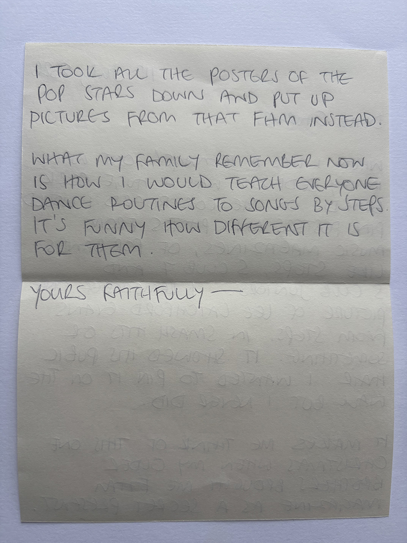 Handwritten note on pale paper reading: 'I took all the posters of the pop stars down and put up pictures from that film instead. What my family remember now is how I would teach everyone dance routines to songs by steps. It's funny how different it is for them. Yours faithfully'.