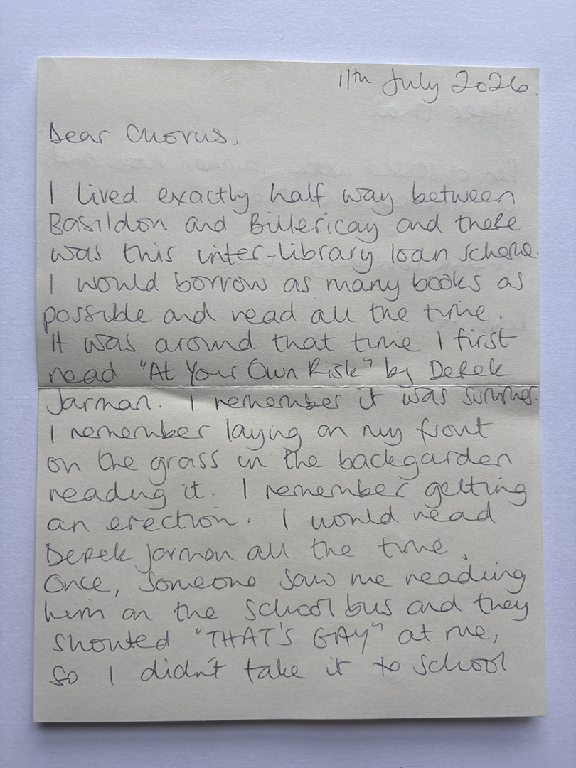 A handwritten letter dated 11th July 2026 addressed to 'Chorus,' describing the writer's experience living between Basildon and Billericay, borrowing books via an inter-library loan scheme, and reading 'At Your Own Risk' by Derek Jarman during summer, including remembering laying on the grass, reading, and an incident where someone shouted "THAT'S GAY" at them on the school bus, leading to not taking the book to school.