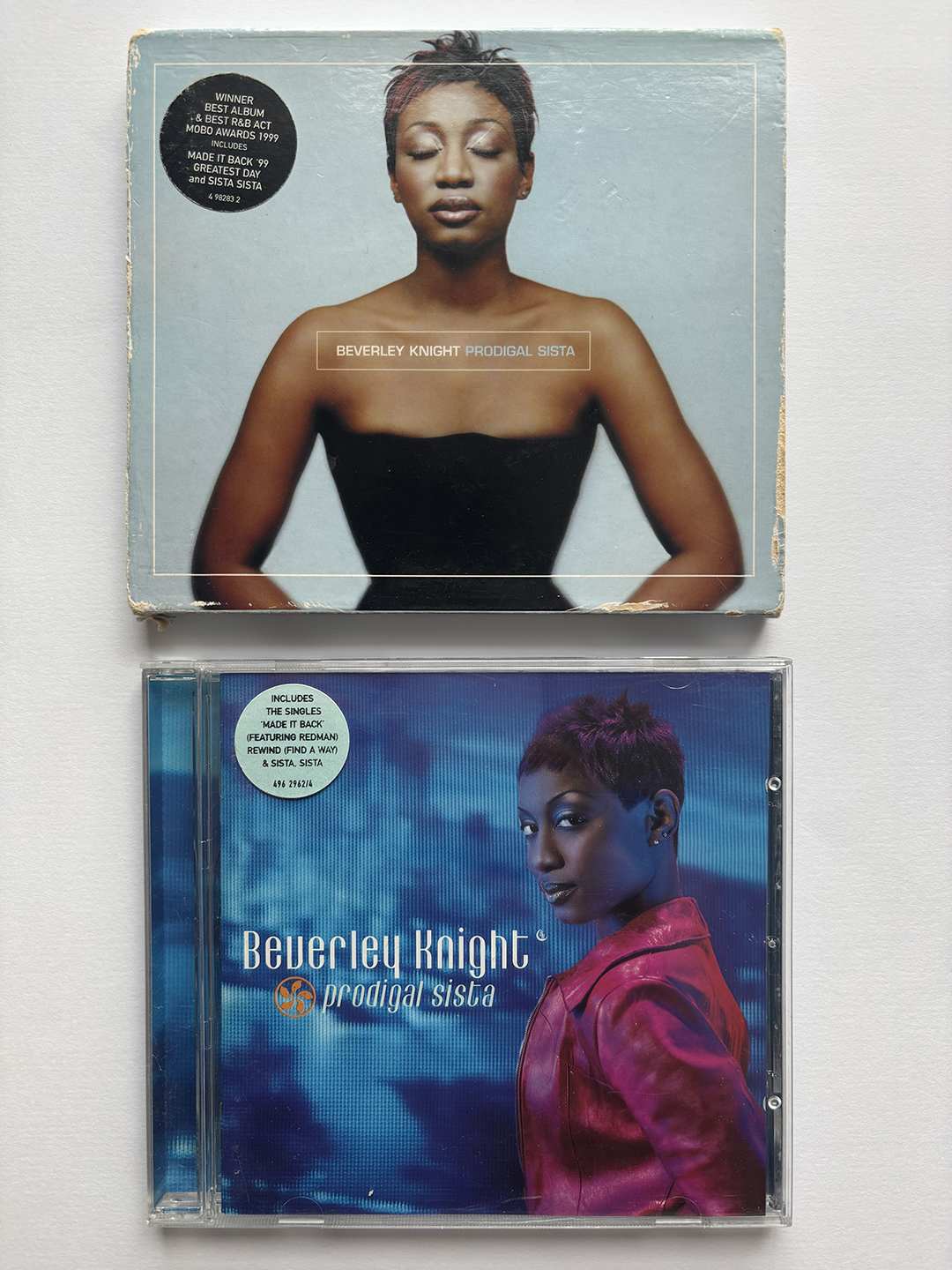 Two album covers of Beverley Knight's 'Prodigal Sista': the top one features a close-up of Beverley with eyes closed against a muted blue background, the bottom shows her in a red jacket looking over her shoulder against a textured blue background.