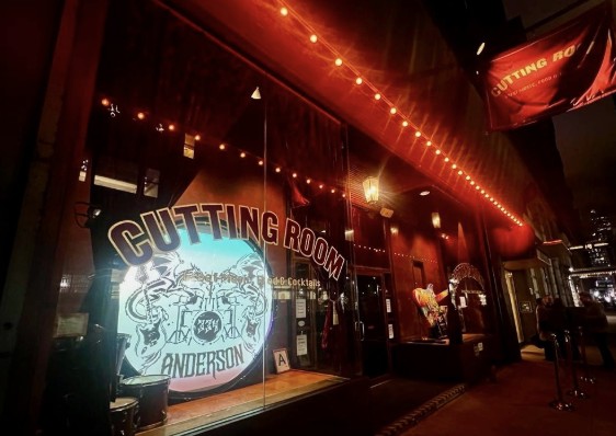 The Cutting Room’s window lit up with the Anderson Music Benefit logo