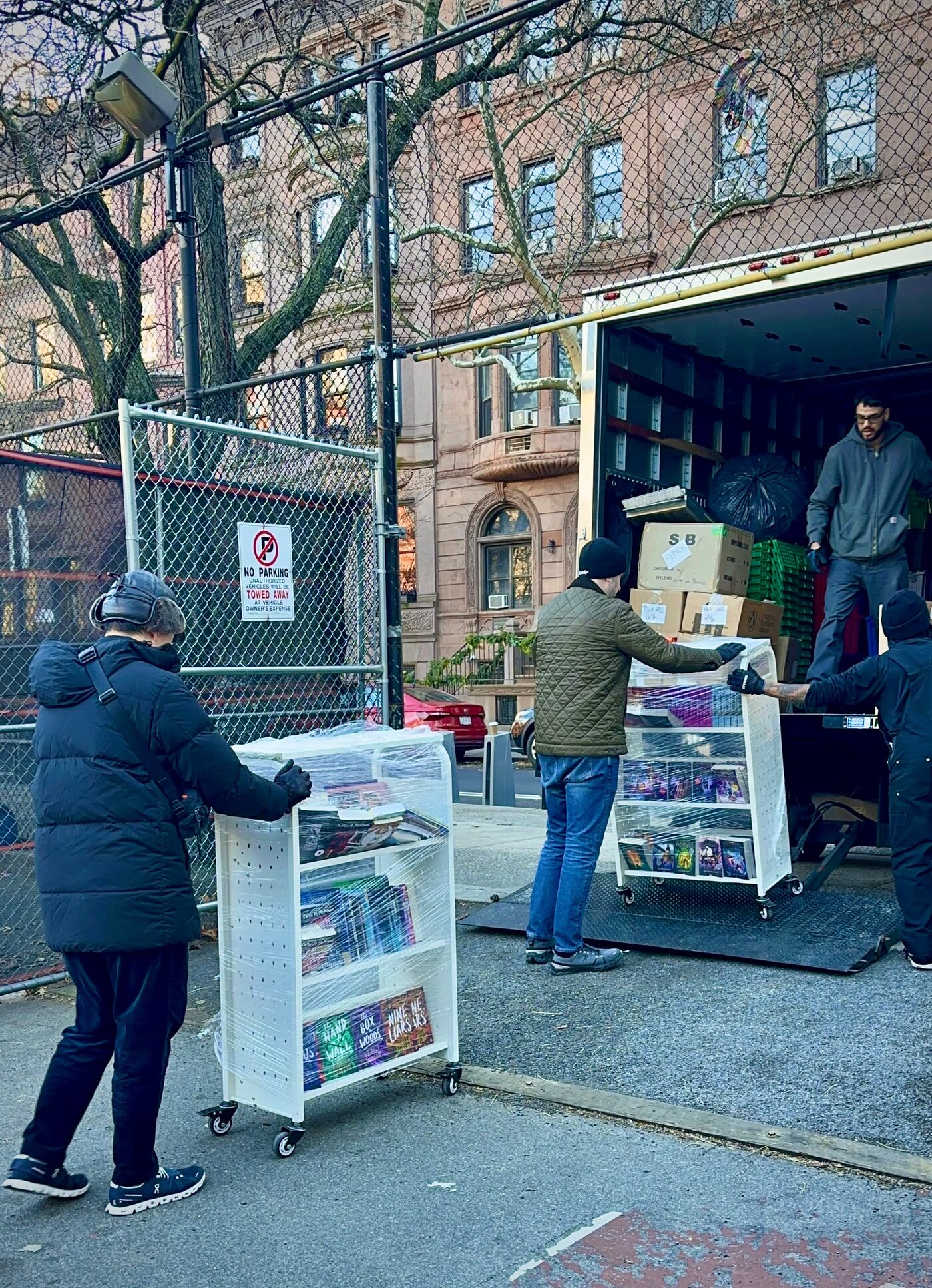 Anderson parent volunteers wheeling carts of books off a delivery truck for the Book Fair